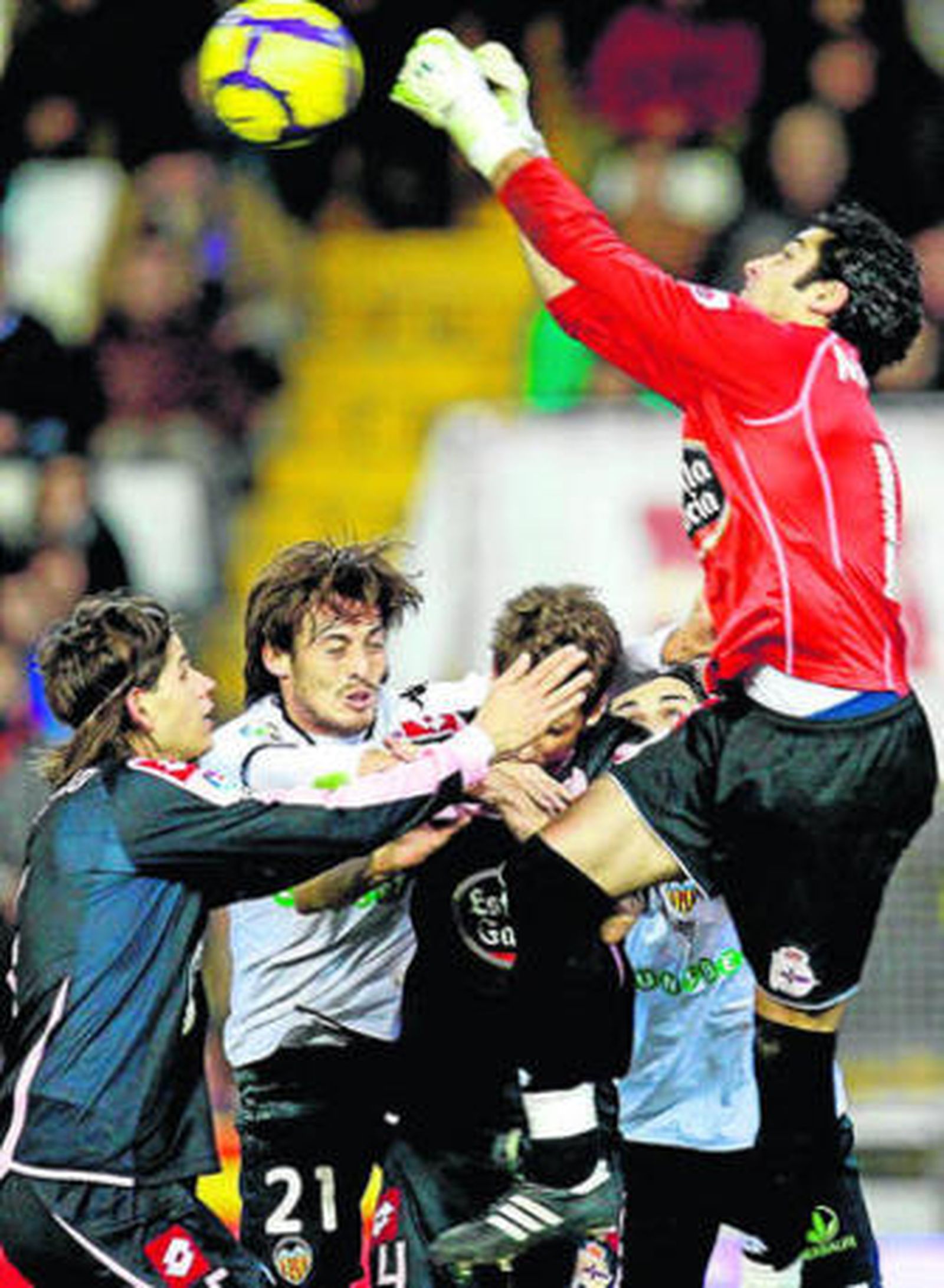 El portero deportivista, Manu, despeja de puños.