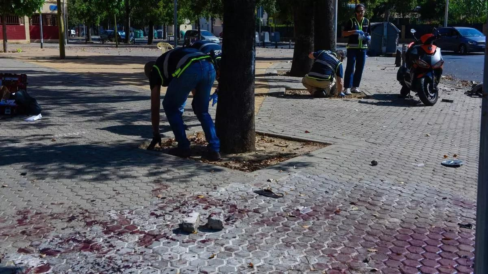 Un policía recoge un posible vestigio en el lugar de los hechos, en las Tres Mil Viviendas.