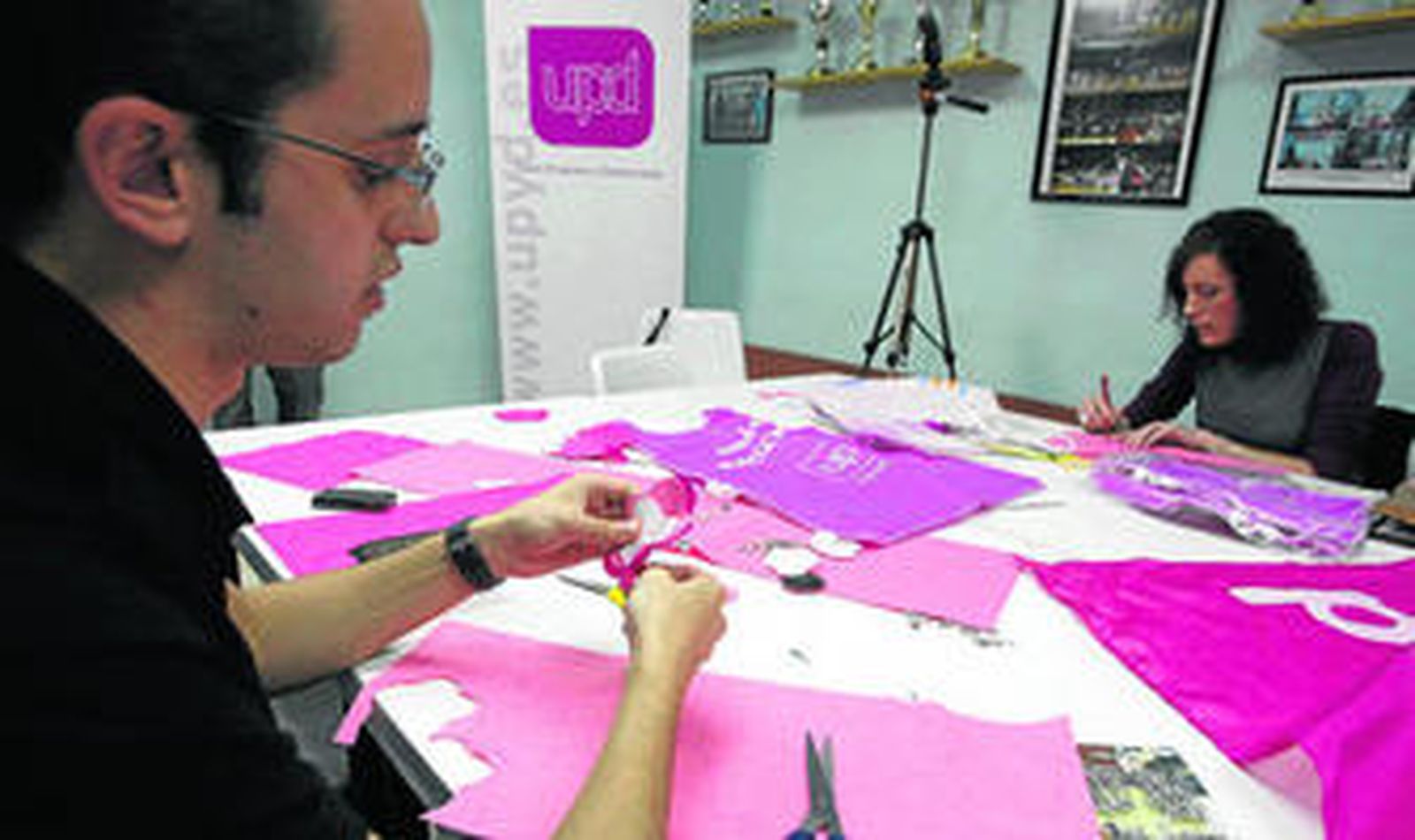 Algunos miembros de UPyD recortan los fieltros para hacer unas rosas  de manera manual que se entregarán durante la campaña.