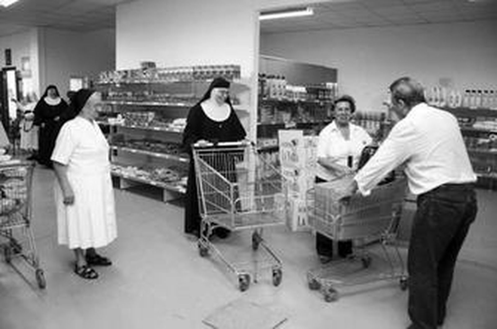 Monjas y voluntarios, con los carritos de la compra del economato.