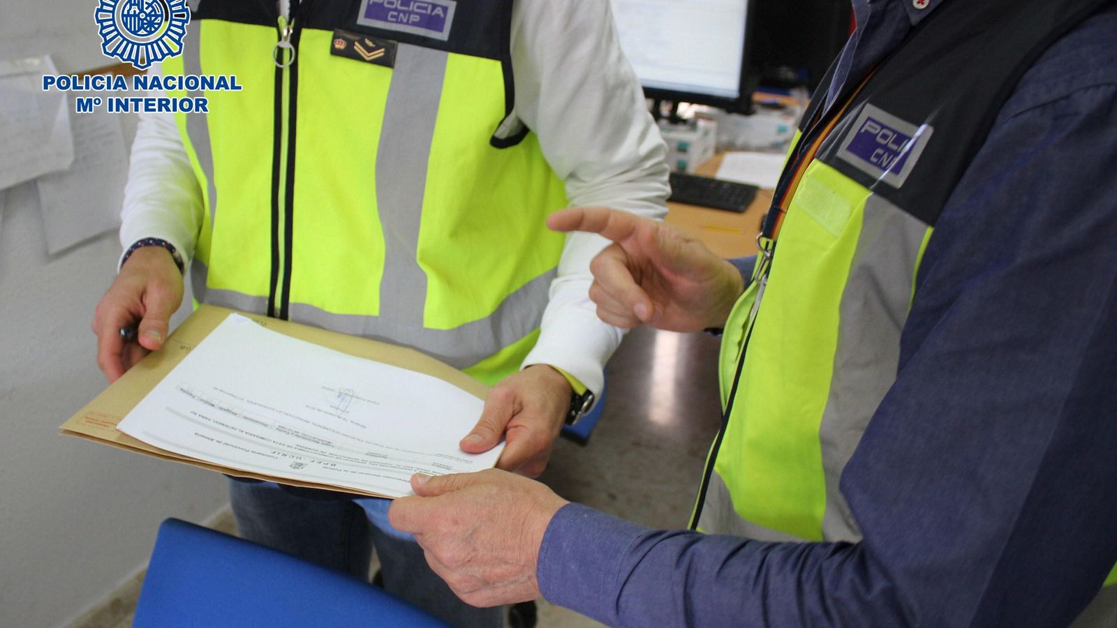 Agentes de la Policía Nacional estudian la documentación fraudulenta.