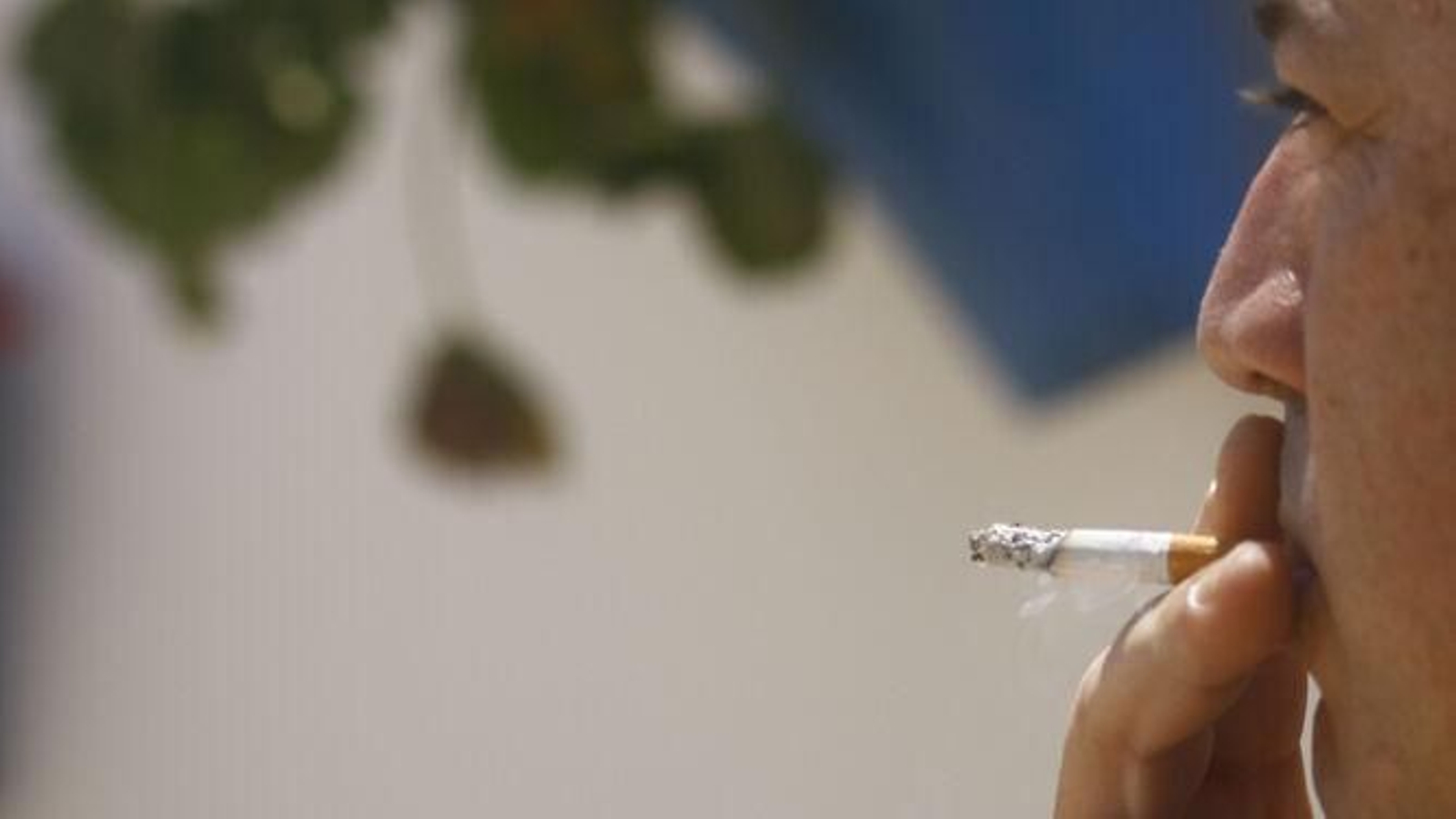 Un hombre fumando en un espacio público.