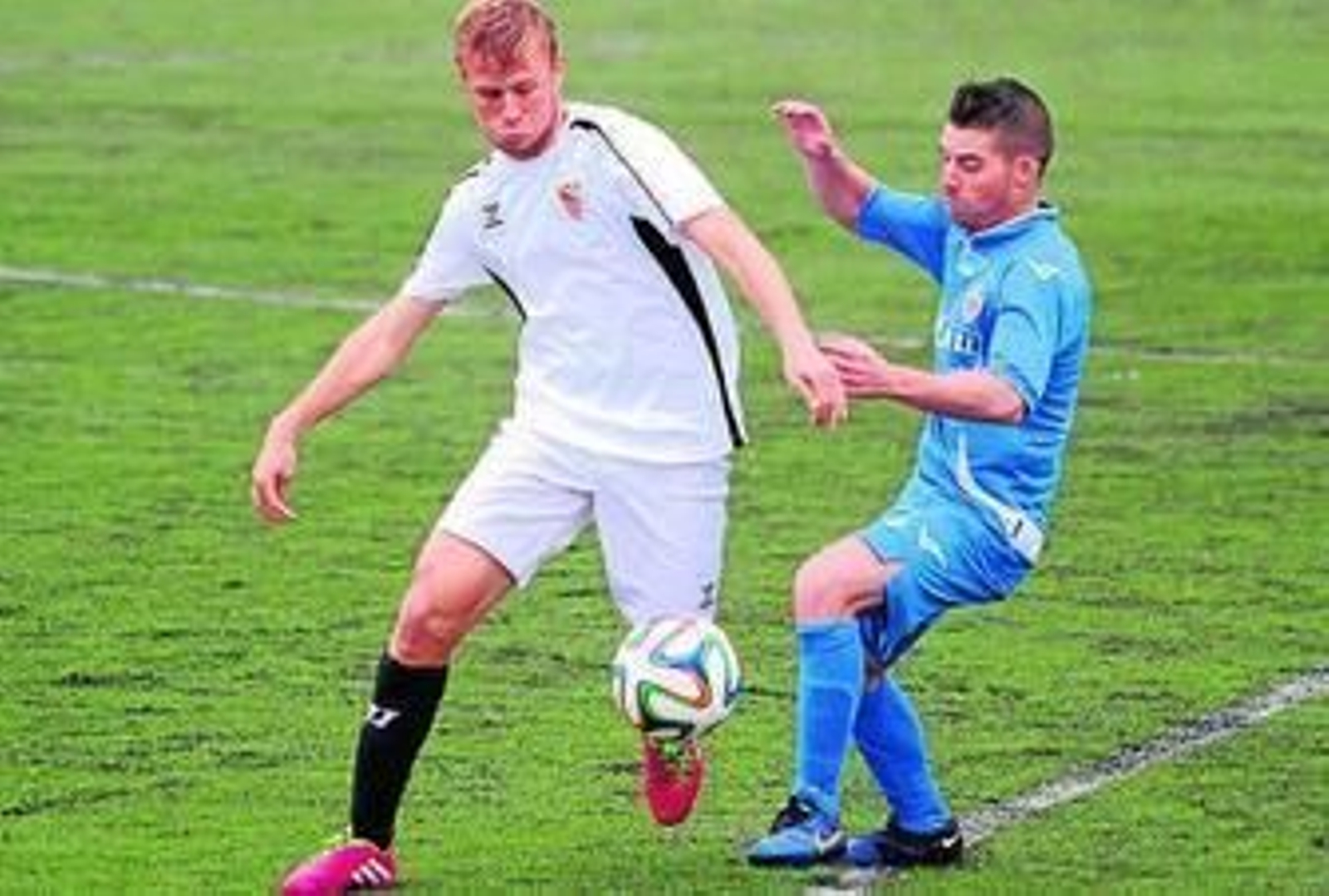 El sevillista Bugatto pelea por un balón en el centro de campo.