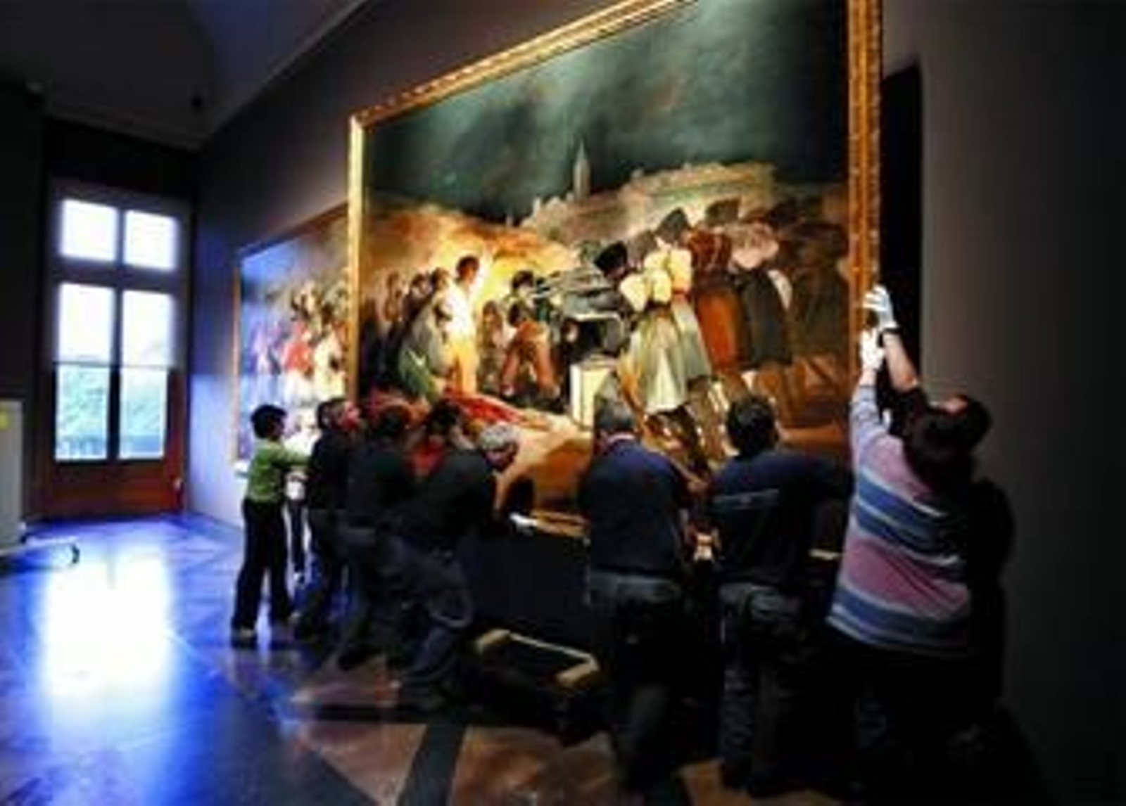 Empleados del Prado cuelgan 'Los fusilamientos del 3 de mayo'.