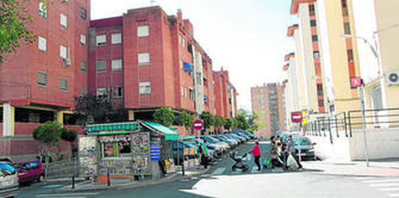 Varios vecinos de Los Rosales transitan por la avenida Amadís de Gaula, en su esquina con la calle Rocinante, dos de las vías principales del barrio.