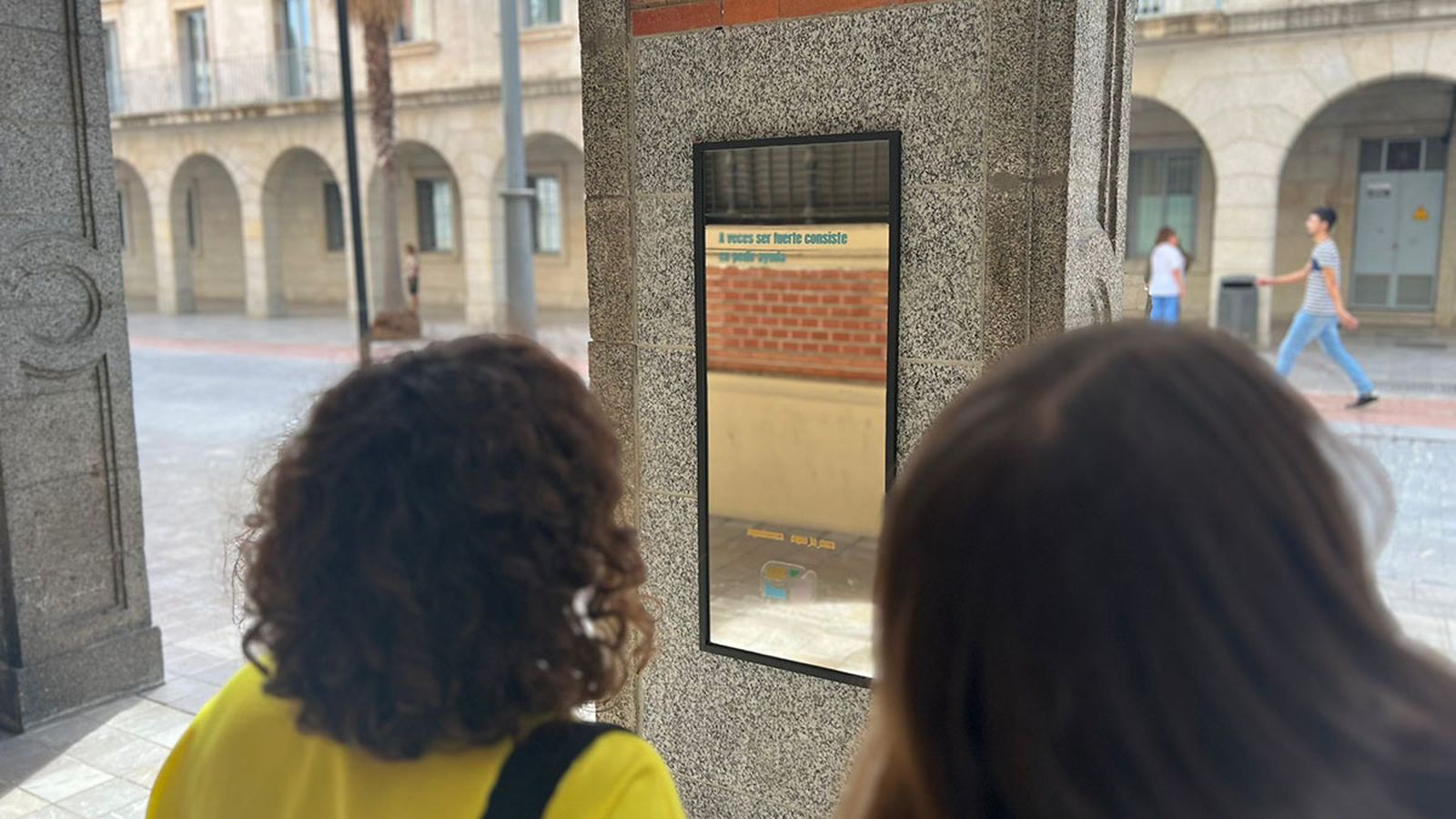 Dos personas se detienen ante uno de los espejos de la Gran Vía de Huelva.