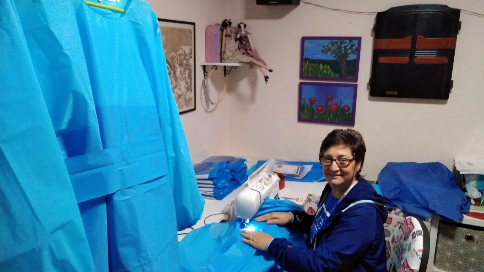 Una de las costureras solidarias cosiendo una bata.