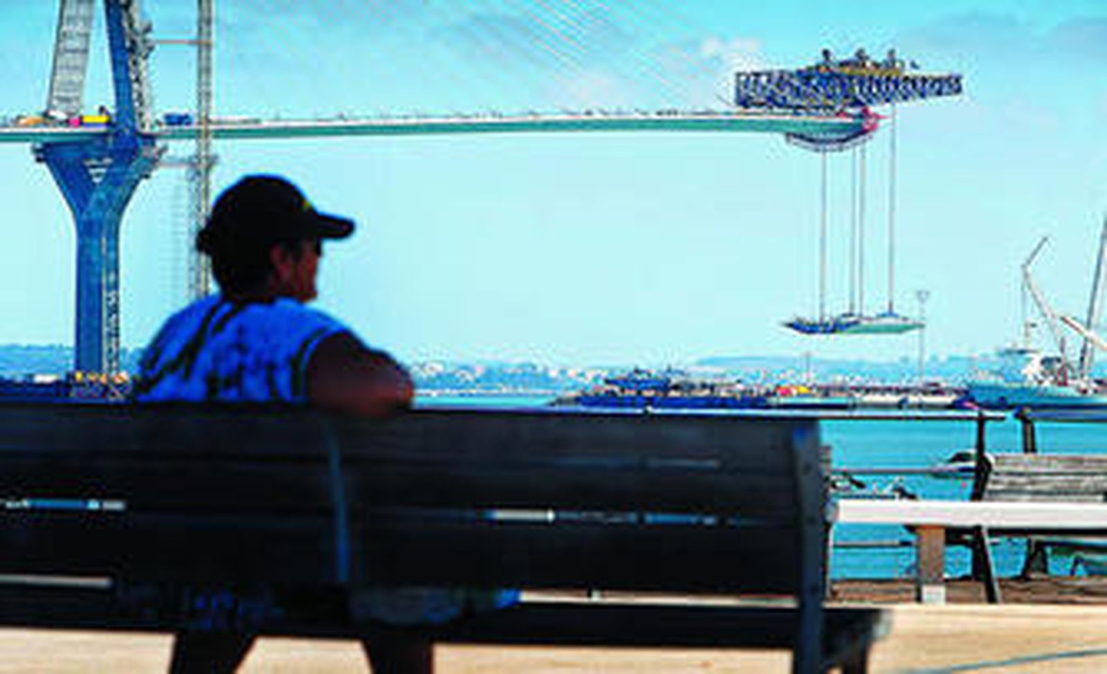 Una persona observa el izado de una nueva dovela en el tramo atirantado del segundo puente.