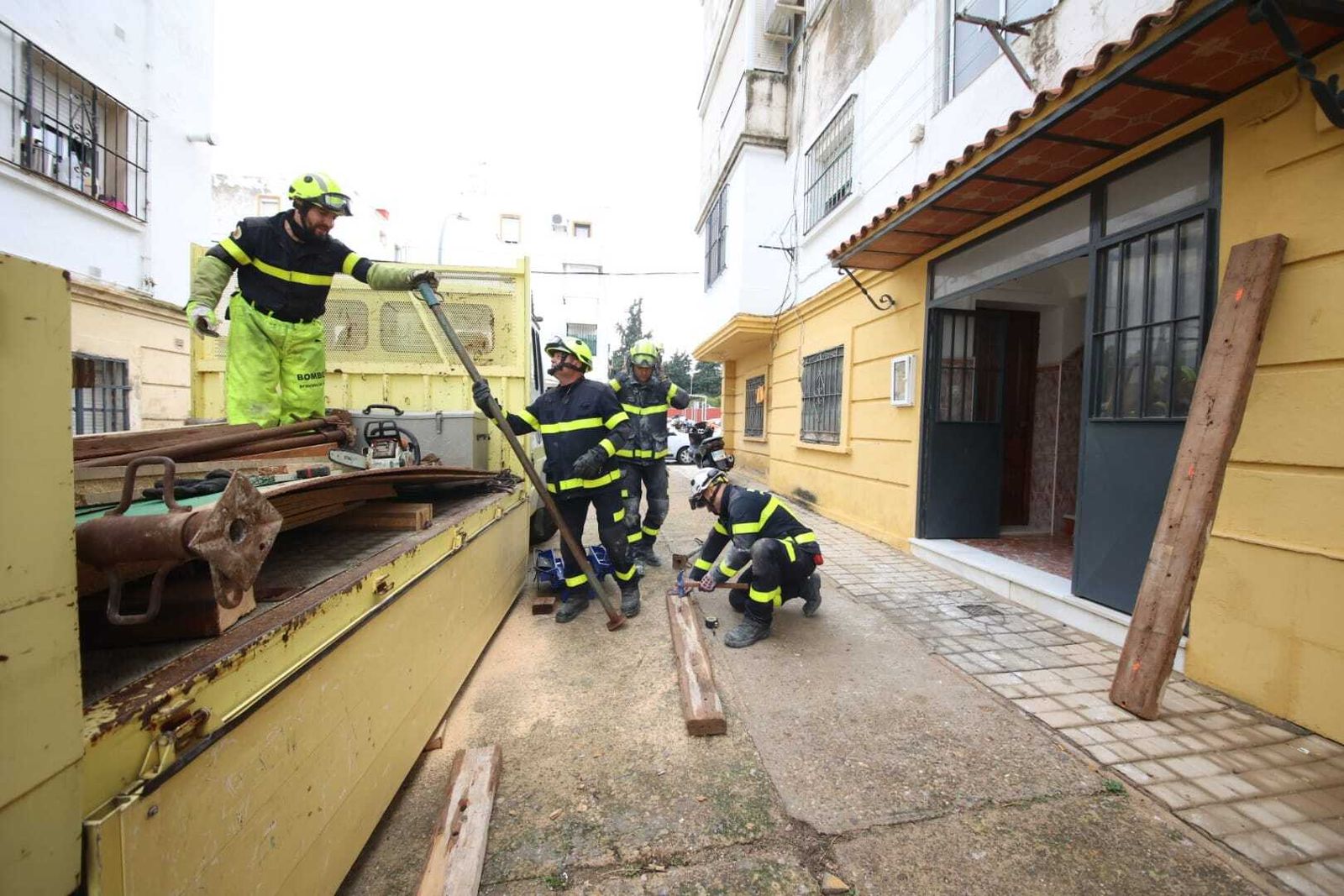 Bomberos apilando el material para apuntalar la vivienda afectada por los desprendimientos en El Carmen.