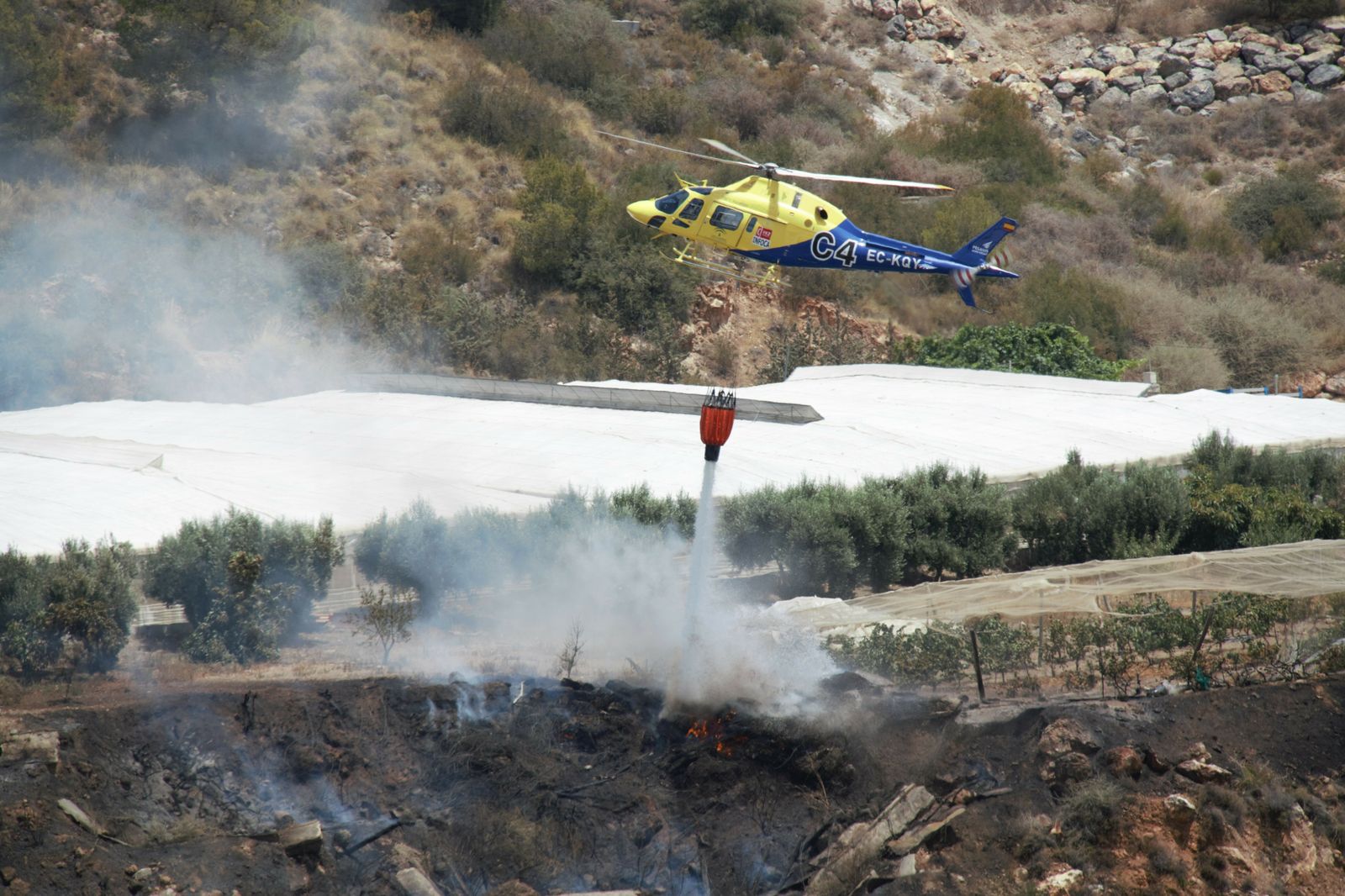 El helicóptero del Infoca, ayer, durante las labores de extinción en el incendio de Motril.