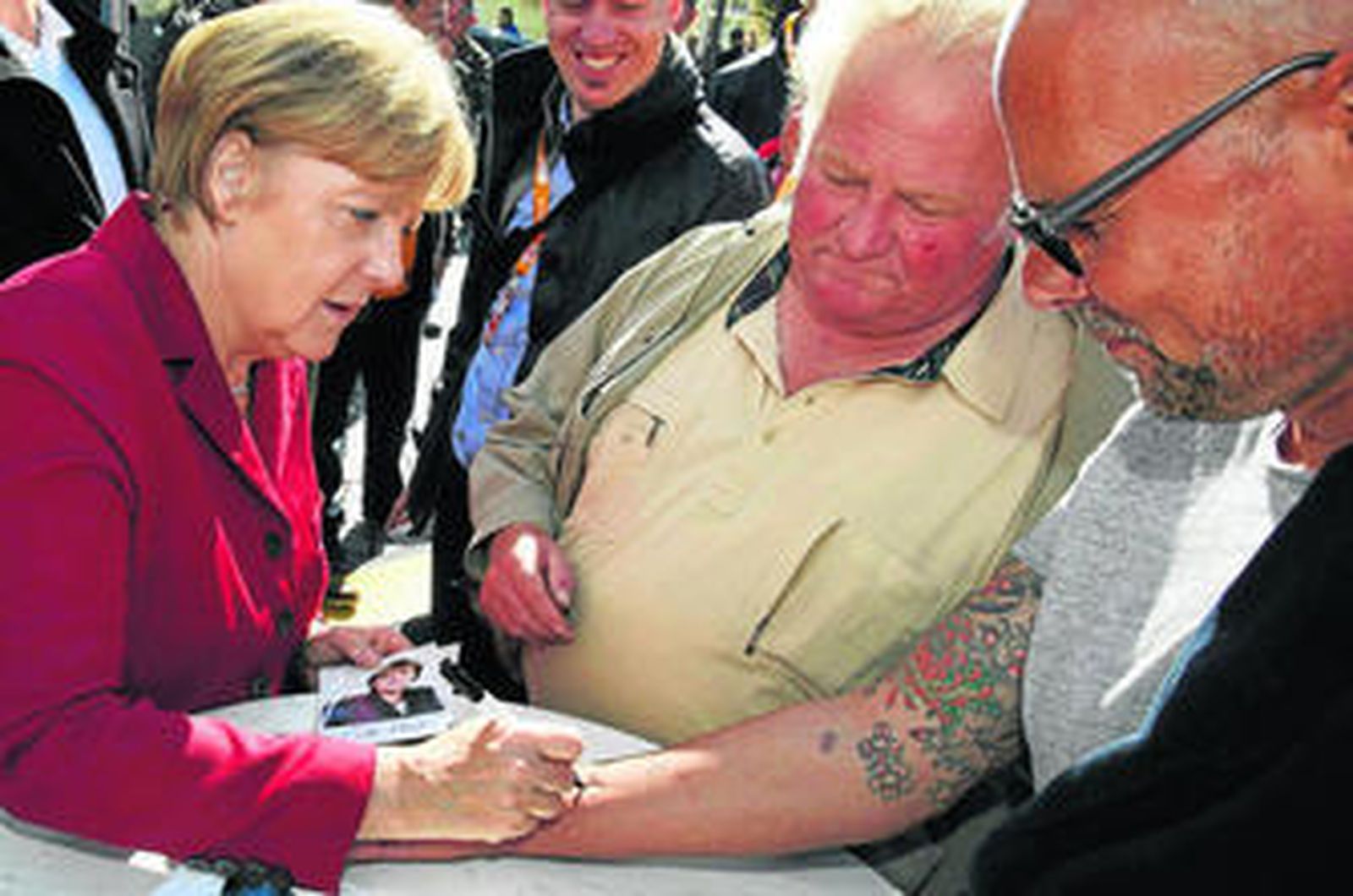 Merkel firma en el brazo de un simpatizante ayer durante un acto de campaña electoral en Ribnitz-Damgarten.