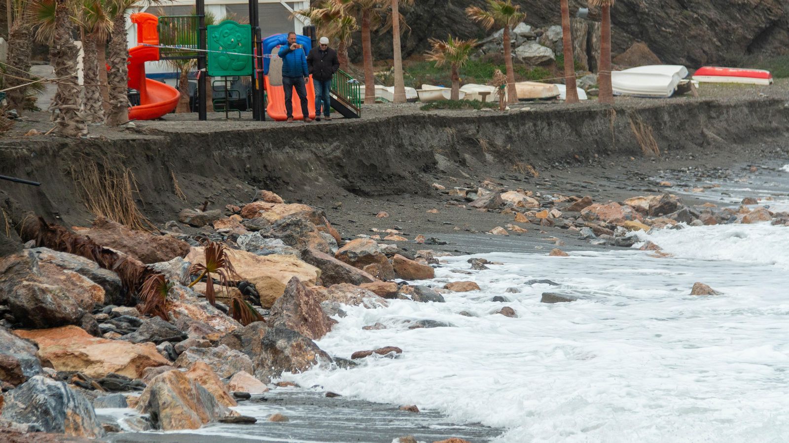 Dos vecinos pasean por lo que queda de playa en Melicena Dos vecinos pasean por lo que queda de playa en Melicena
