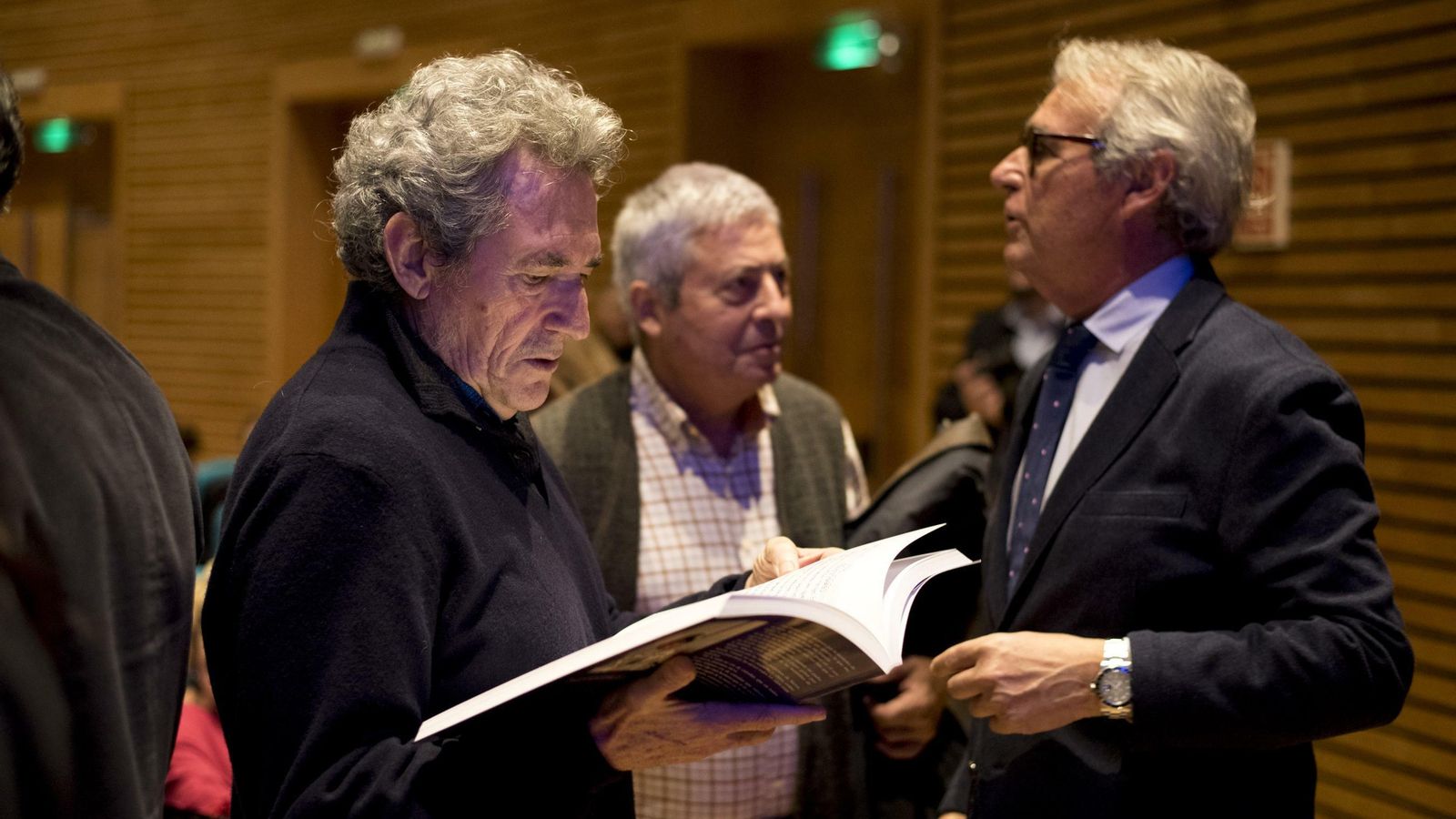 Miguel Ríos observa detenidamente el libro.