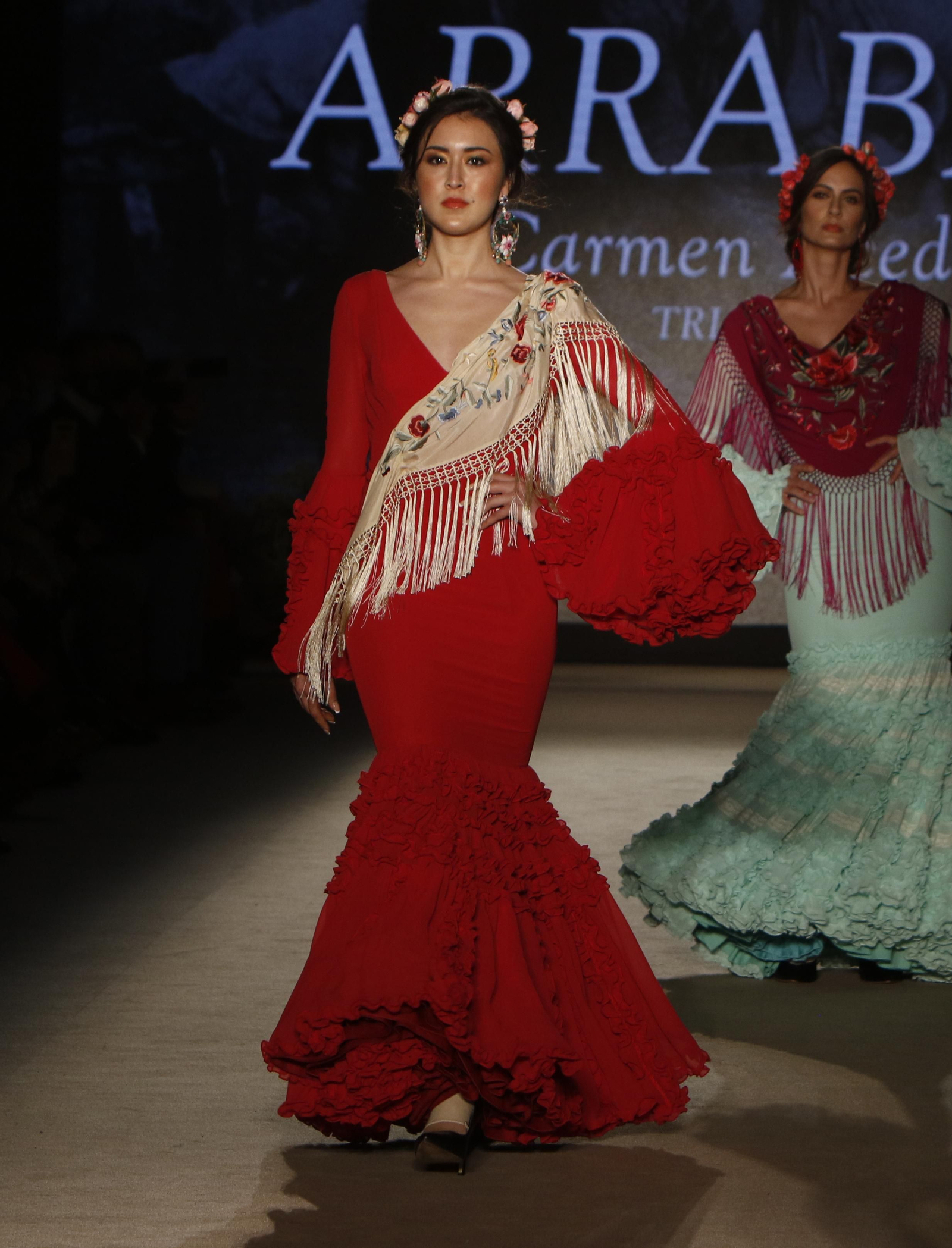 Traje de flamenca rojo combinado con un mantoncillo crudo de Carmen Acedo. Traje de flamenca rojo combinado con un mantoncillo crudo de Carmen Acedo.