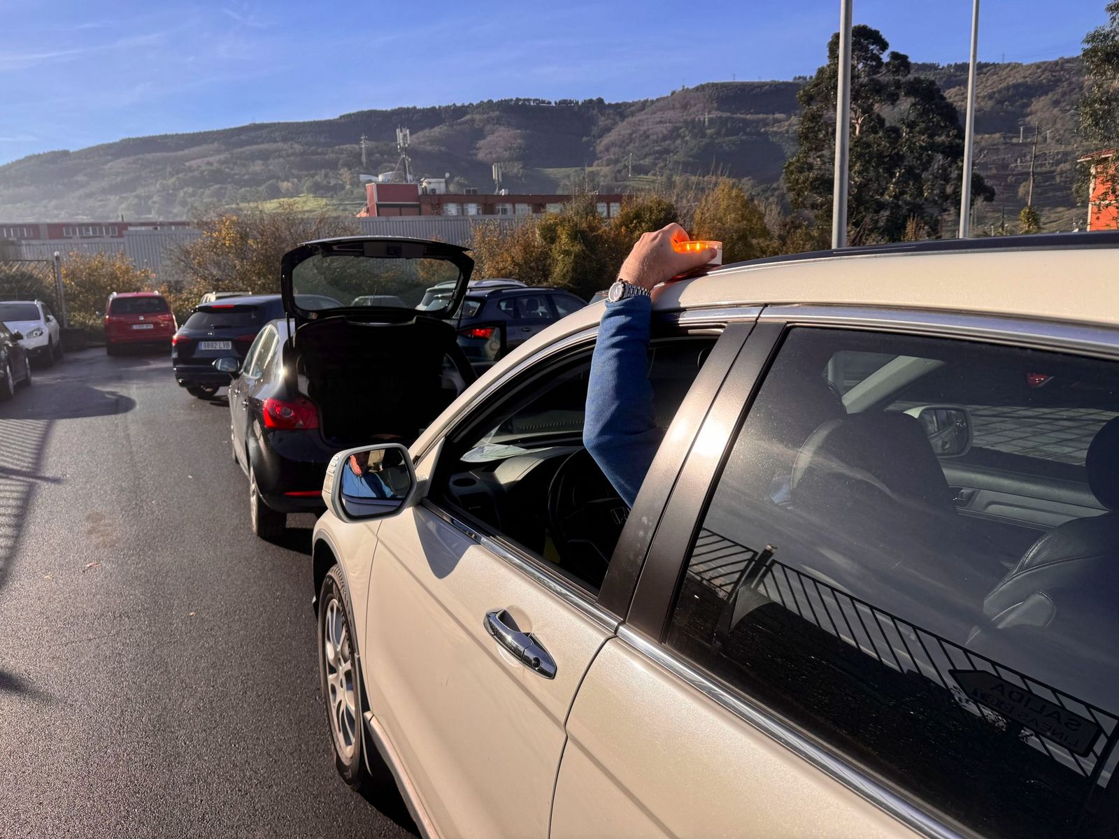 Un conductor coloca una baliza  de emergencias