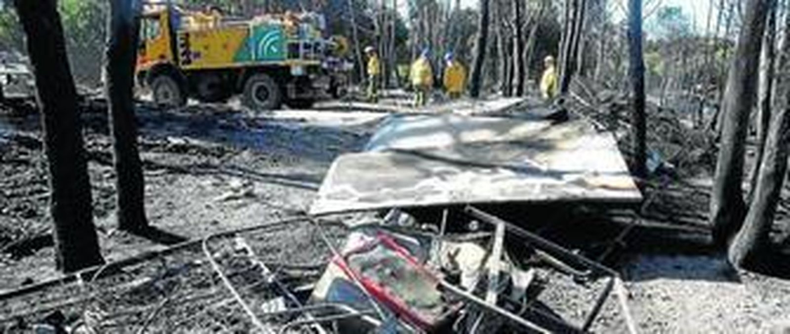 Restos de camas calcinadas, en primer término. Al fondo, parte del dispositivo desplazado hasta la zona siniestrada.