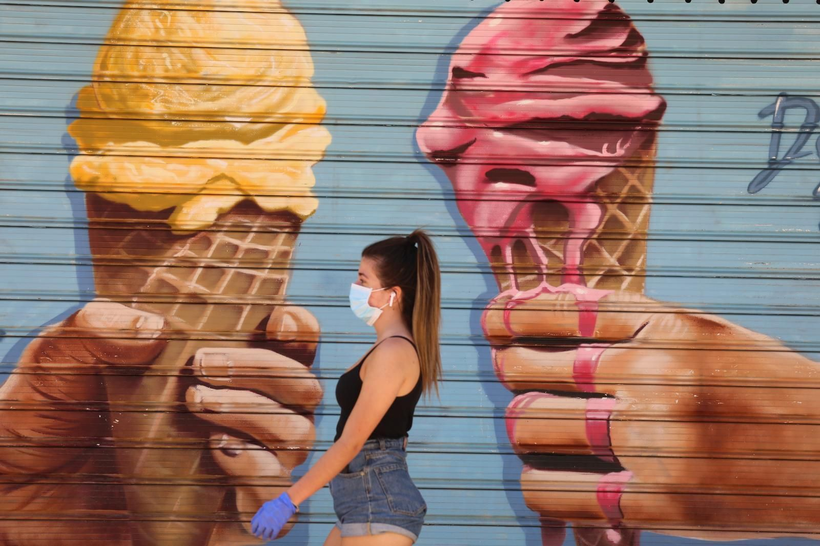 Una joven, con guantes y mascarillas, este lunes en Málaga.