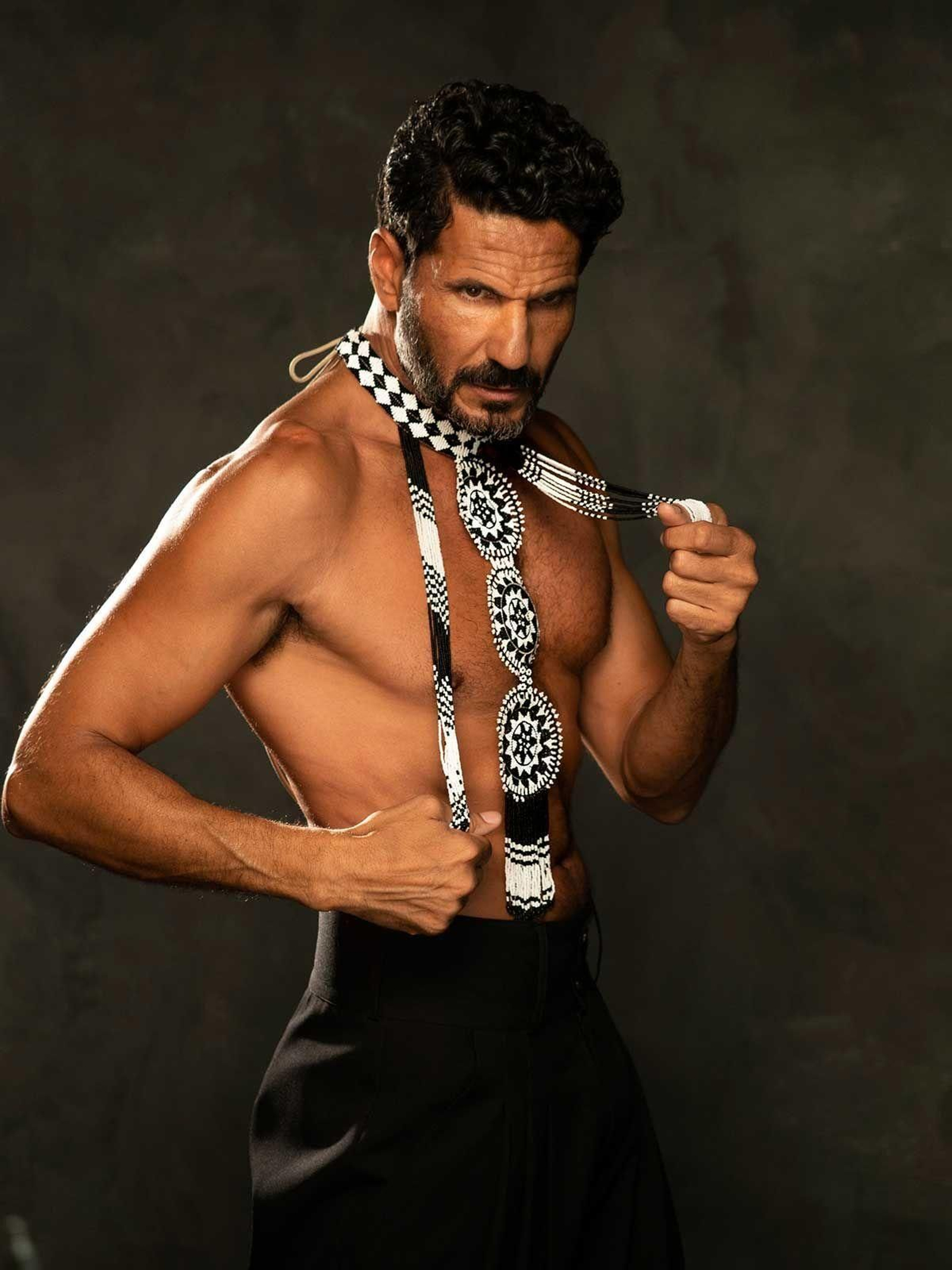 Con uno de los cinturones diseñados por él.