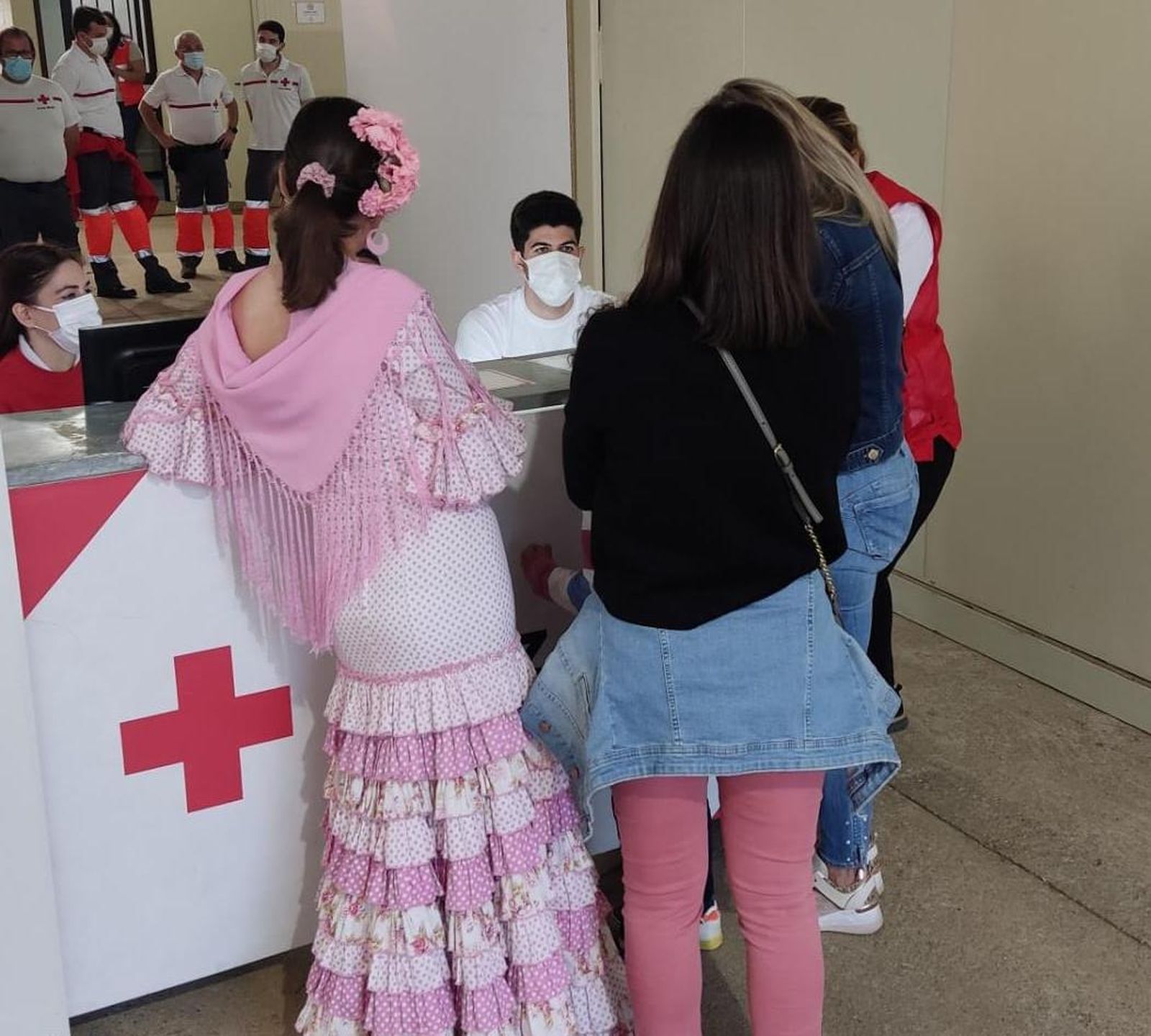 Varias personas acuden al puesto de Cruz Roja en la Feria.