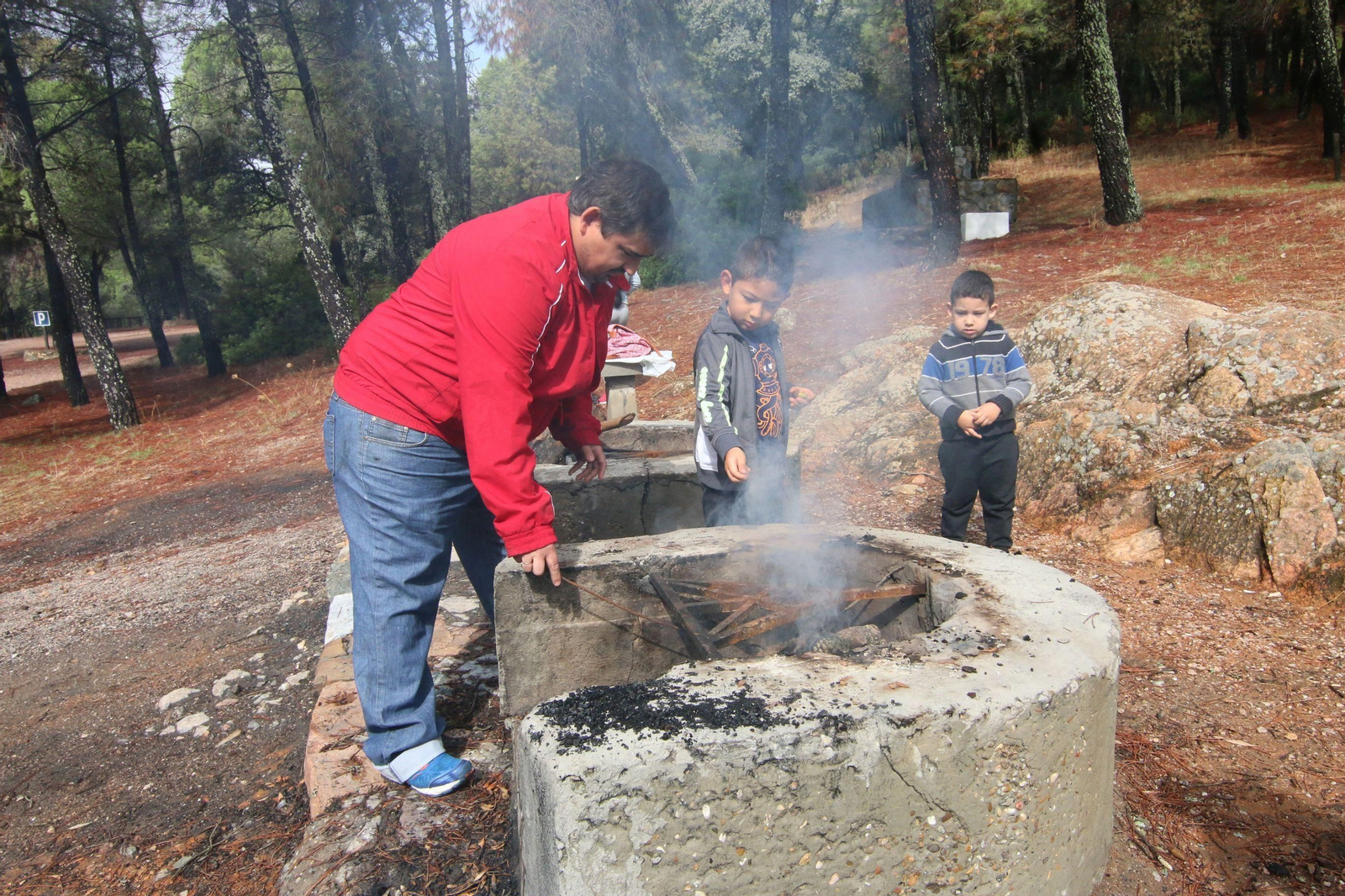 Una familia prepara el fuego para un perol en Los Villares.