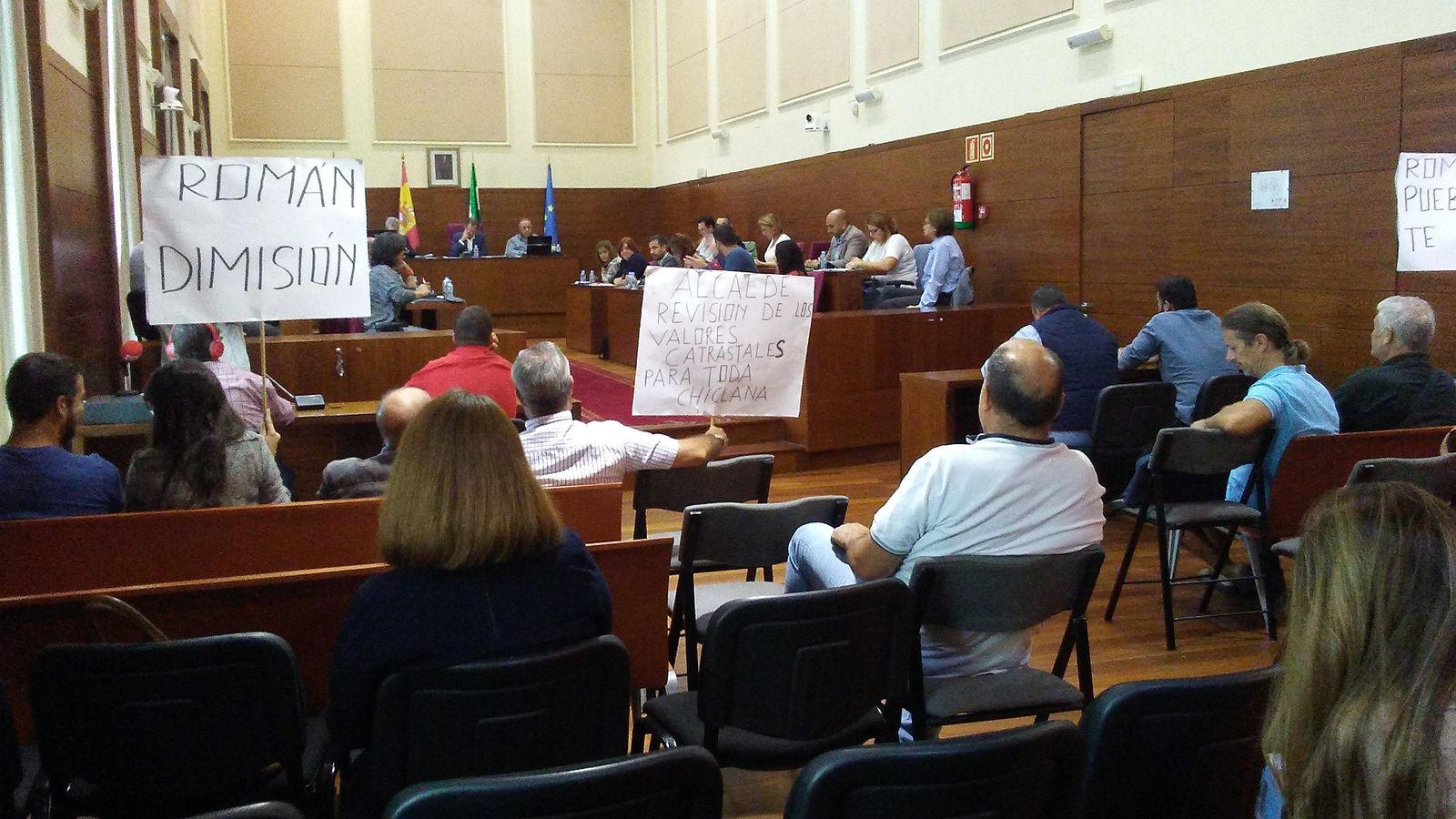 Un momento del pleno extraordinario con pancartas en contra del aumento del impuesto.