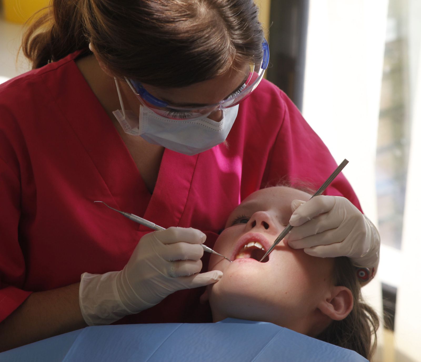 Una odontóloga realiza una revisión a una niña.