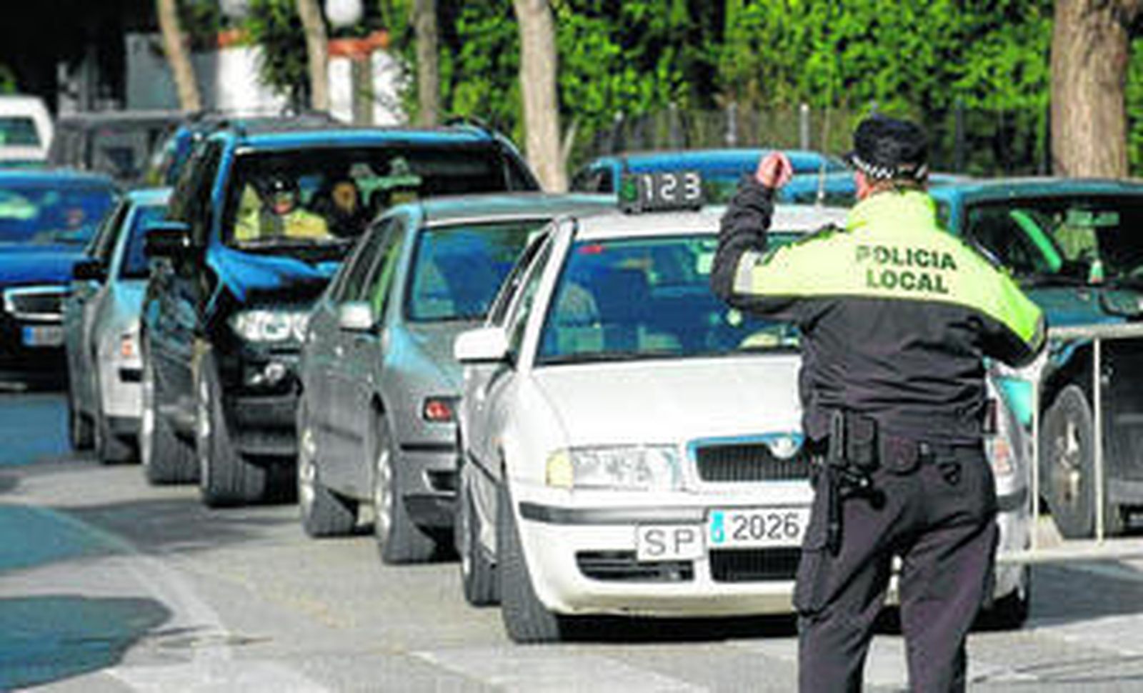 Un agente de la Policía Local realiza señales a un conductor en un control de tráfico.