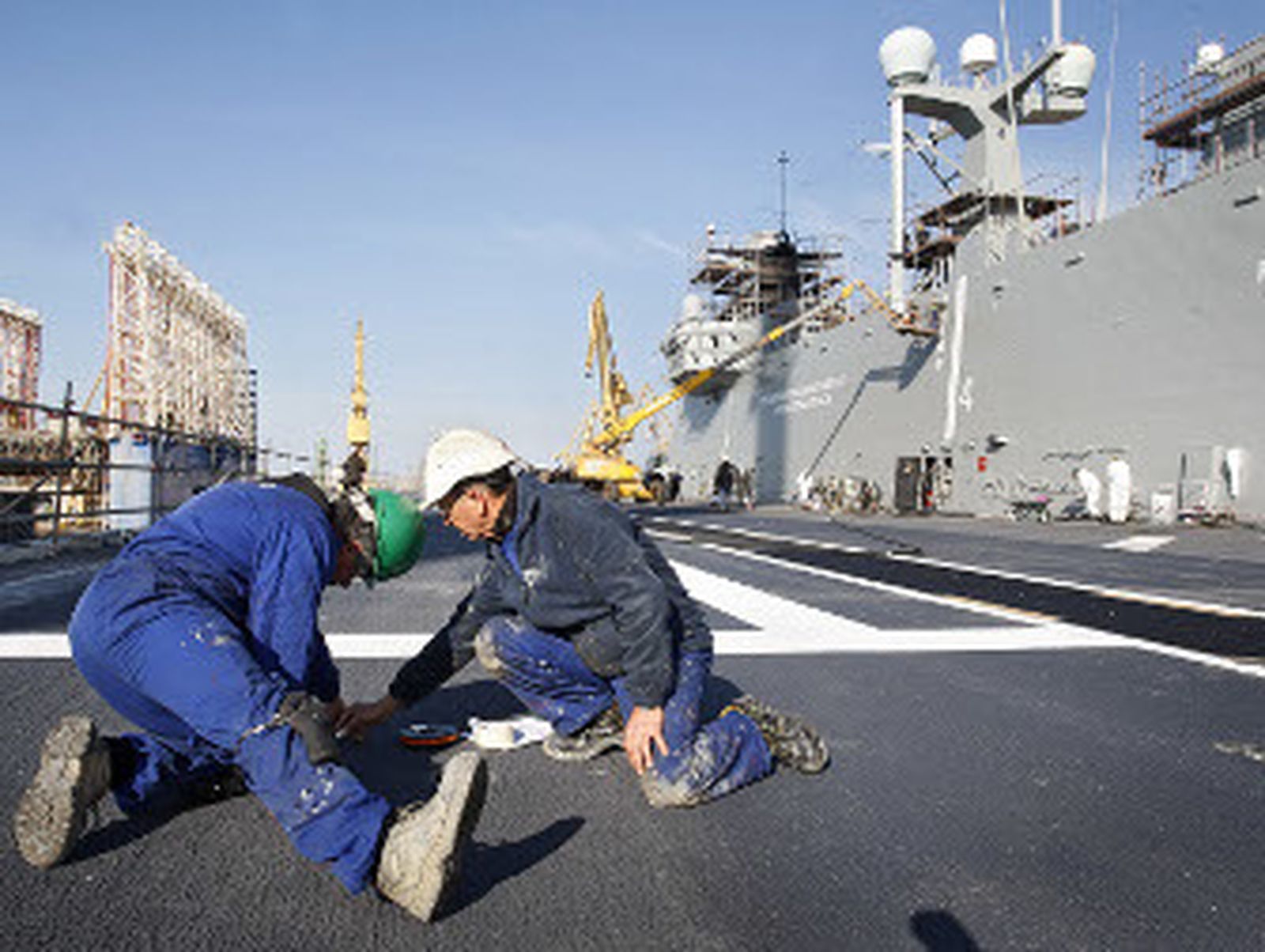 Operarios gaditanos trabajan ayer en el buque de la Armada Española. / Joaquín Pino
