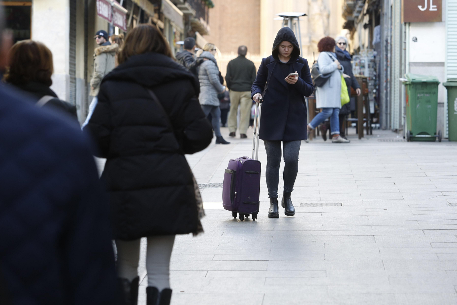 Una turista pasea su maleta por la zona comercial del centro de Granada