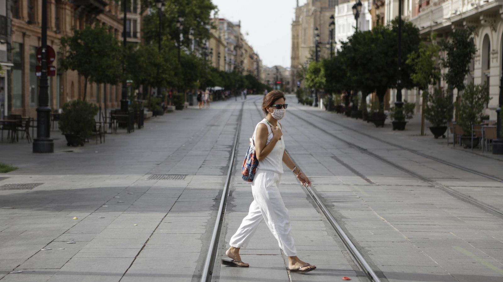 Una joven atraviesa la Avenida de la Constitución.