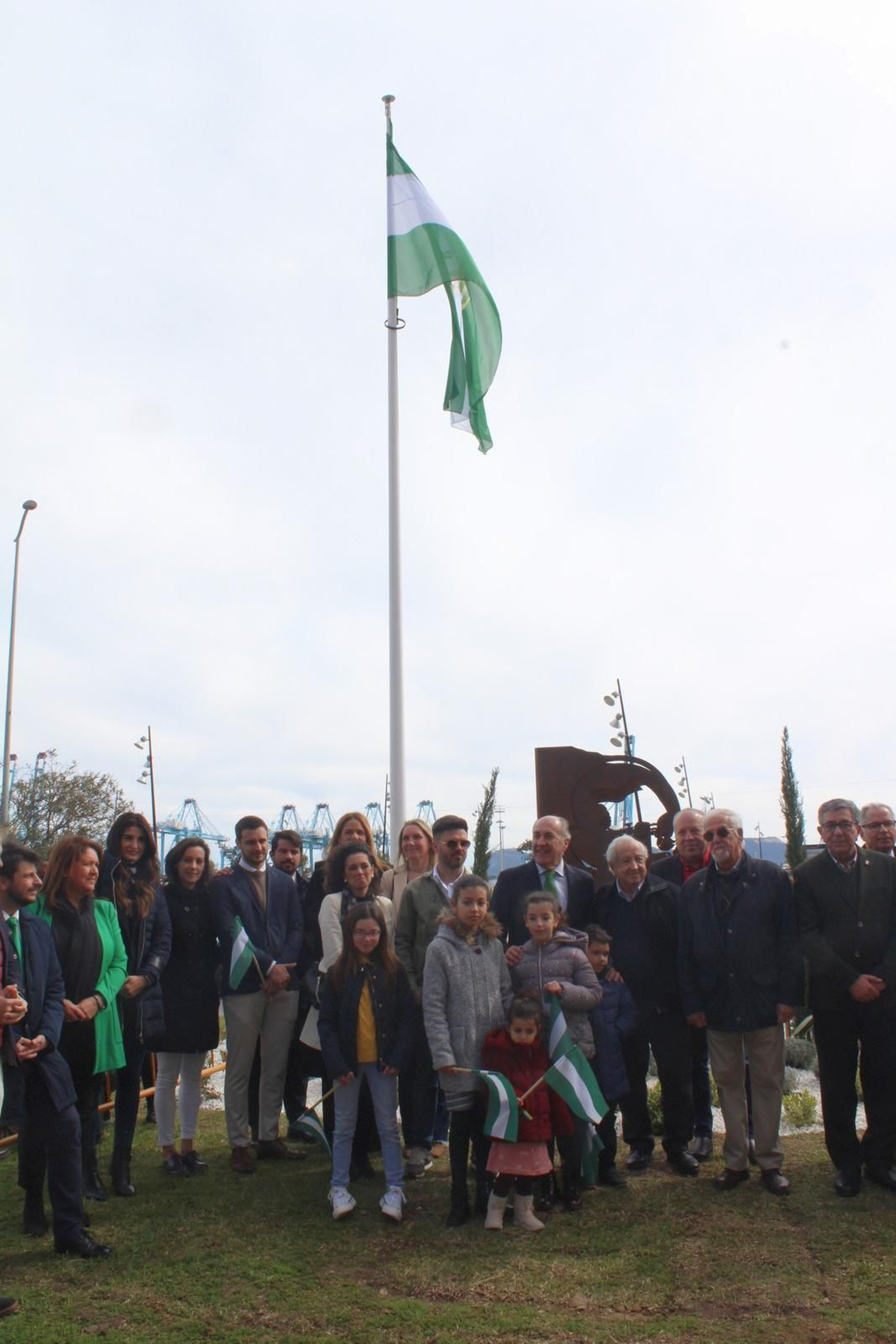Foto de familia frente al nuevo monumento y la bandera de Andalucía