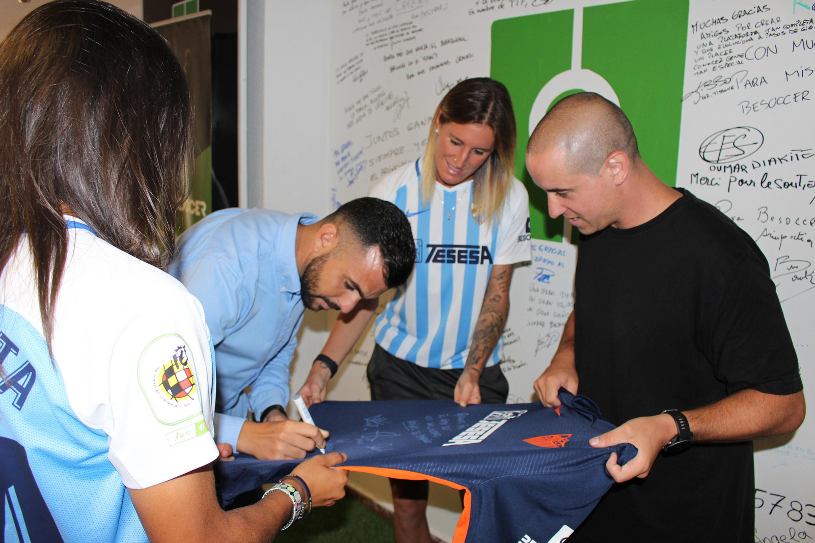 José Herrera firmando la camiseta del Málaga.