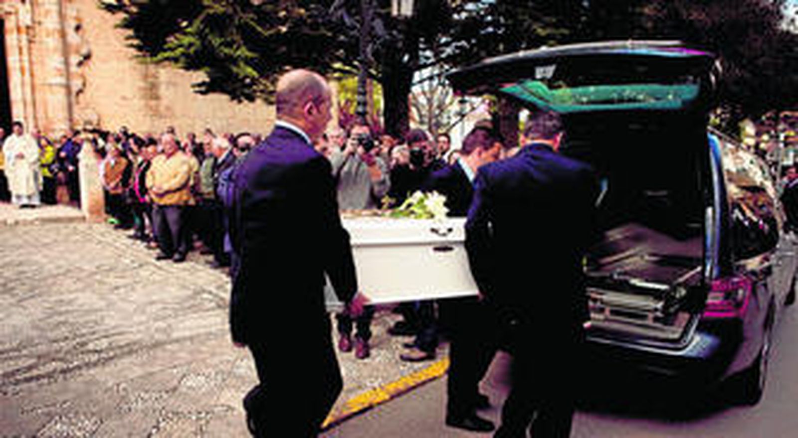 El féretro de la niña es introducido en el coche fúnebre, ayer, tras la misa en su memoria.