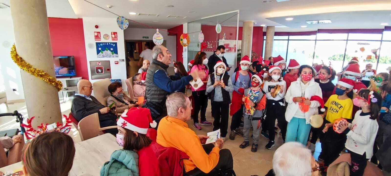 Escolares llenan de villancicos y felicitaciones navideñas las residencias de mayores