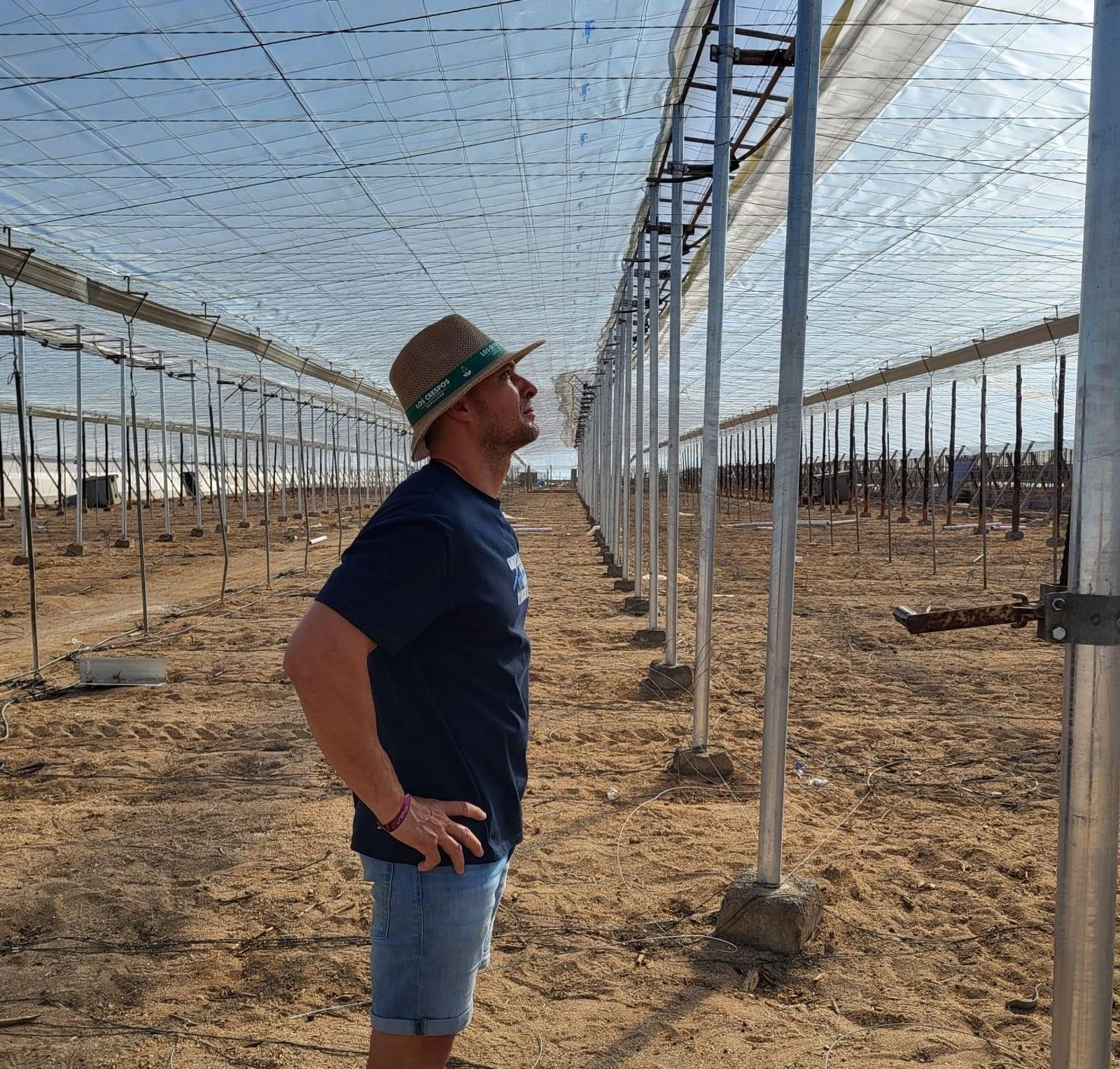 Abel observa cómo han quedado las cubiertas de su invernadero.