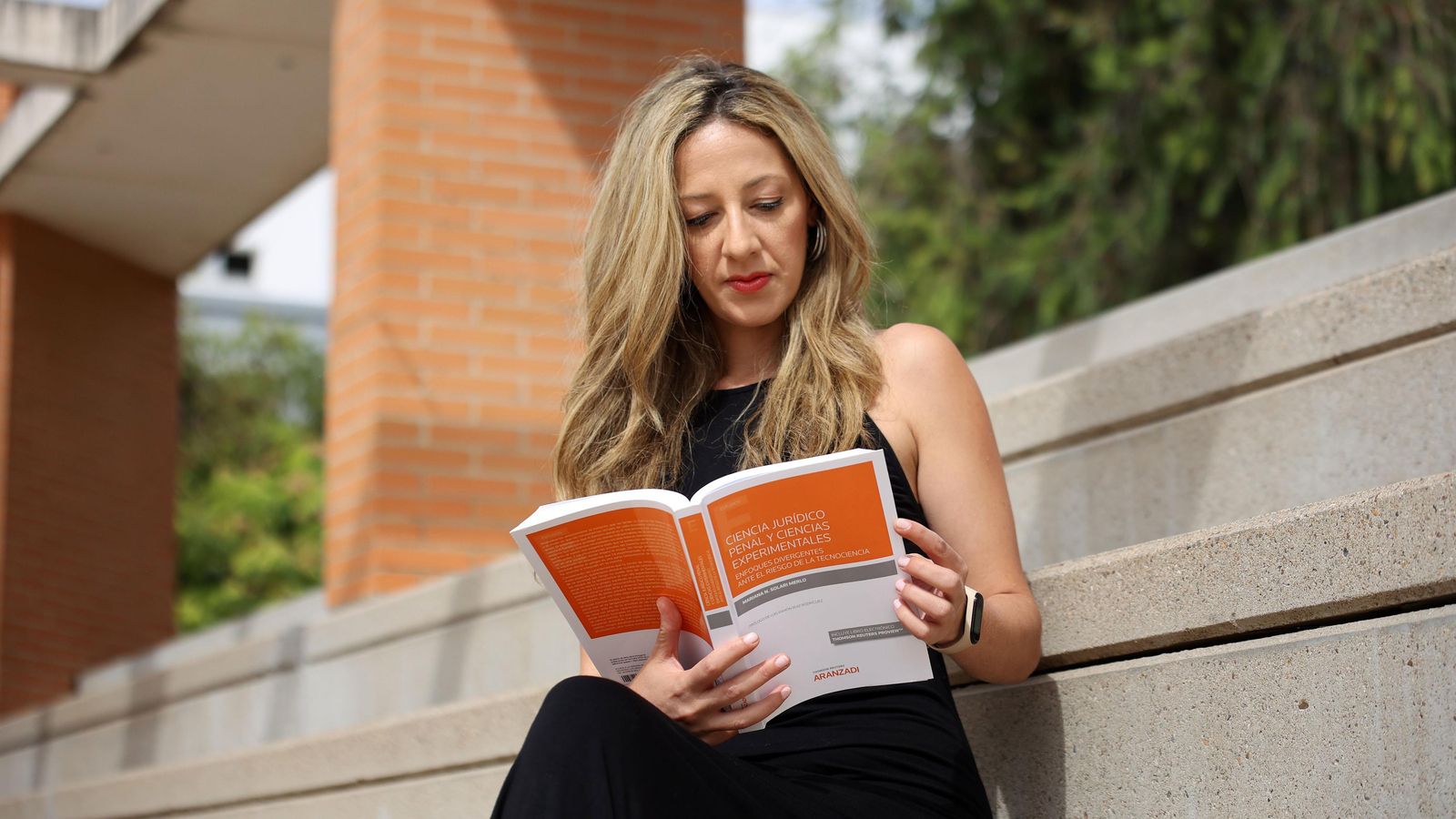 La profesora lee su monografía.