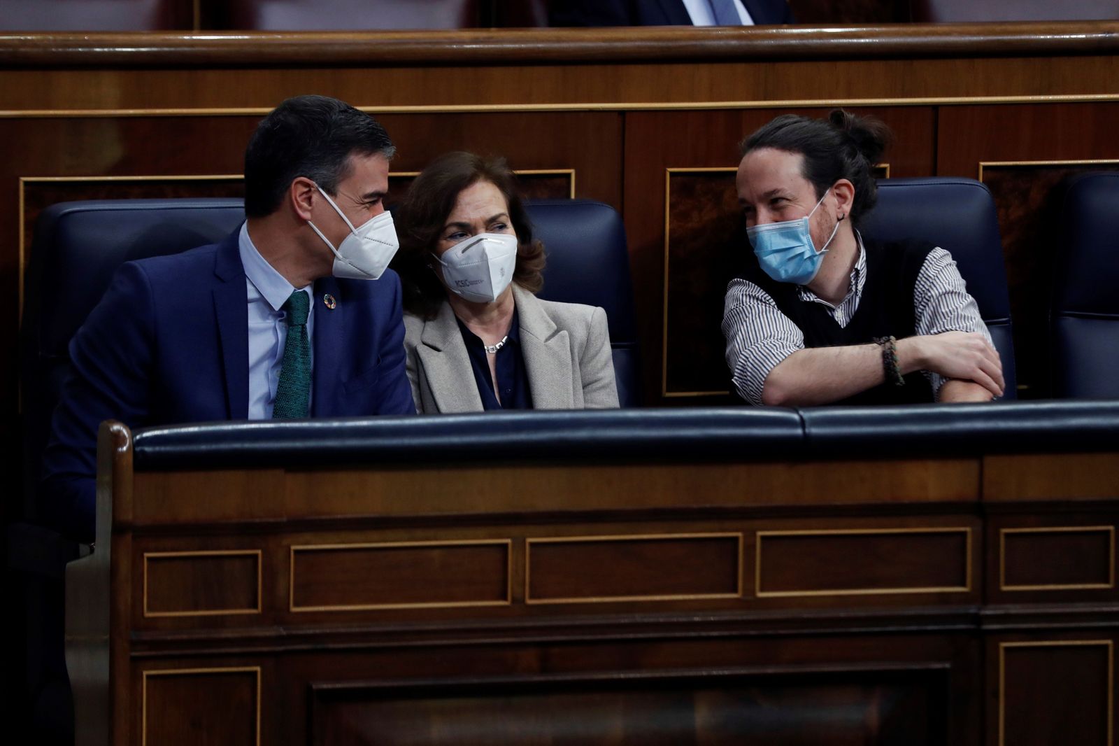El presidente del Gobierno, Pedro Sánchez, conversa con sus vicepresidentes Carmen Calvo, y Pablo Iglesias, en el Congreso este miércoles.