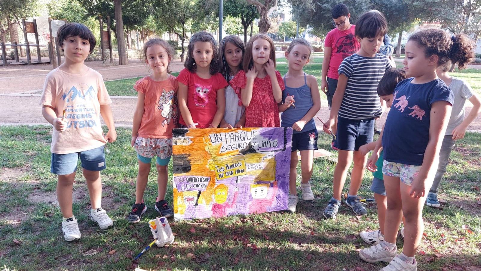 Un grupo de niños muestra el cartel que han elaborado.