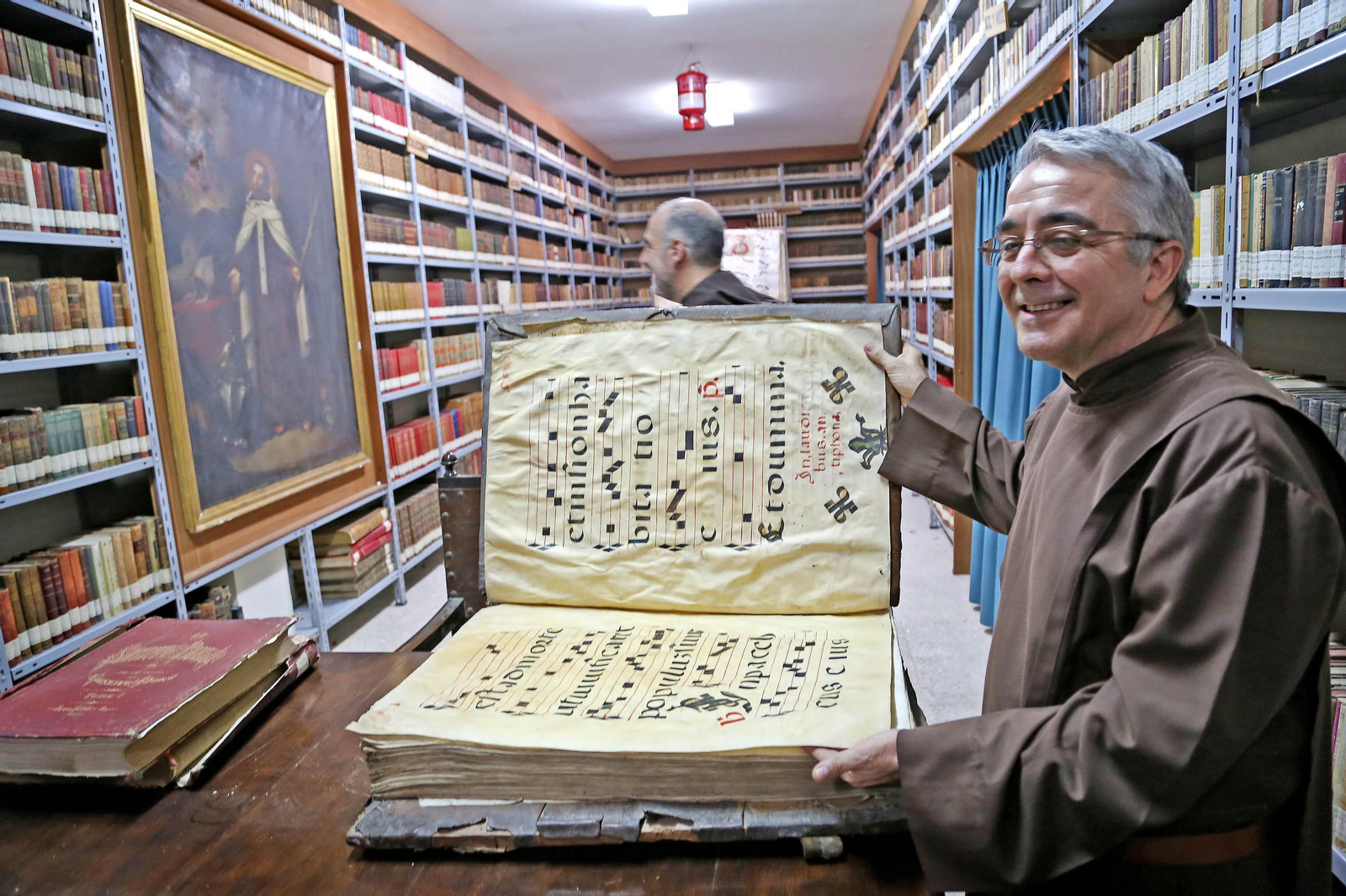 El padre Alejandro Peñalta mostrando libros litúrgicos de la importante biblioteca.
