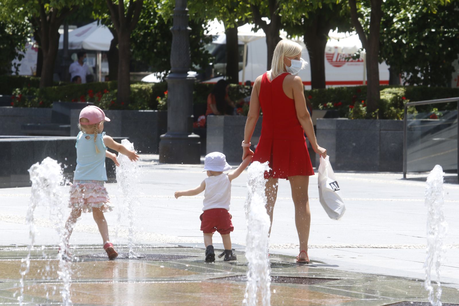 Una madre pasea con sus dos hijas por Las Tendillas.
