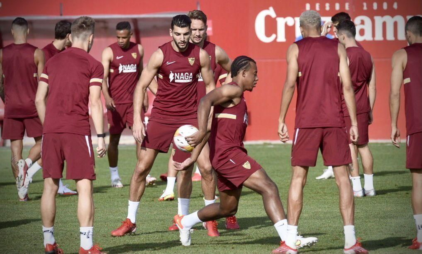Koundé y Rafa Mir, en el centro del rondo durante el entrenamiento sevillista.