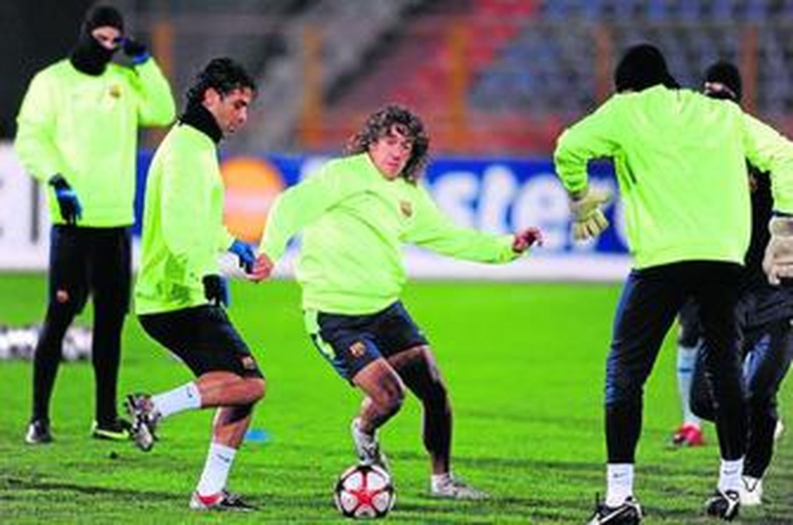 Puyol y Márquez pugnan por un balón.