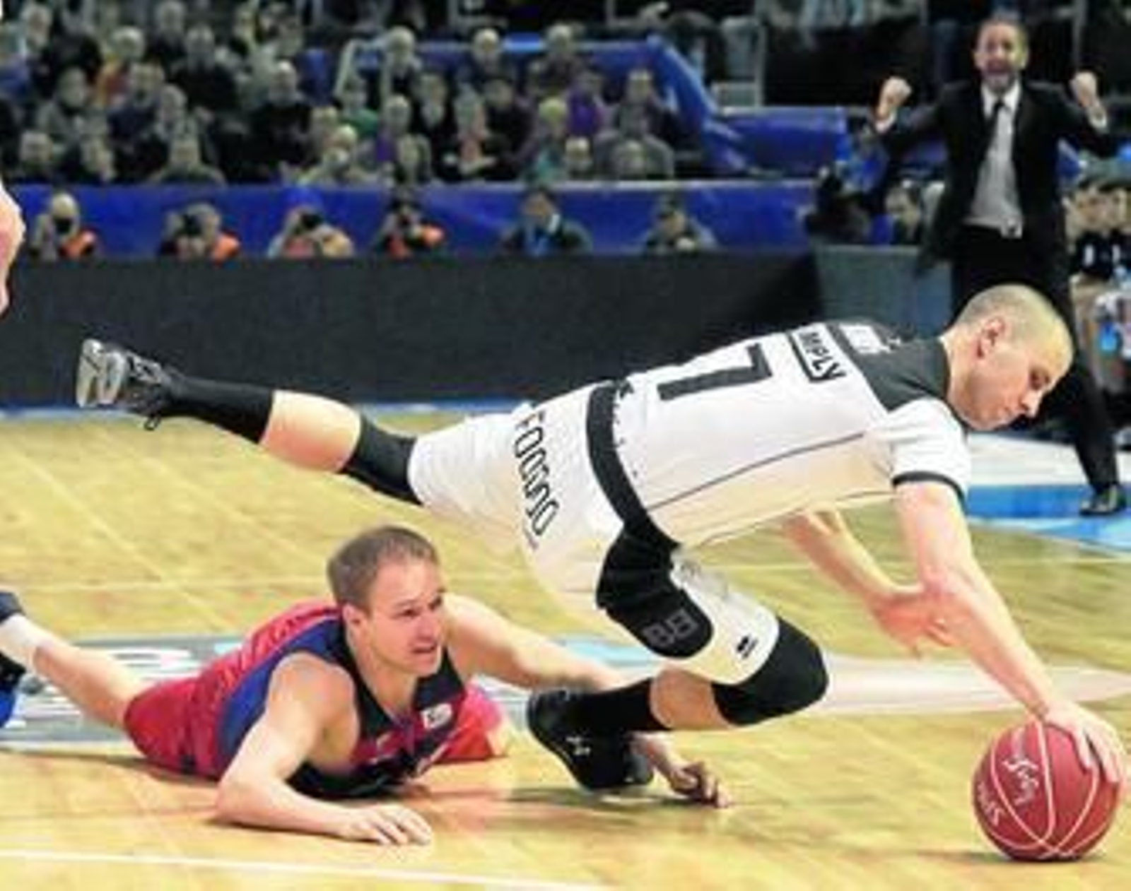 El escolta azulgrana Oleson y el alero bilbaíno Ruoff pelean por la pelota a ras de suelo.