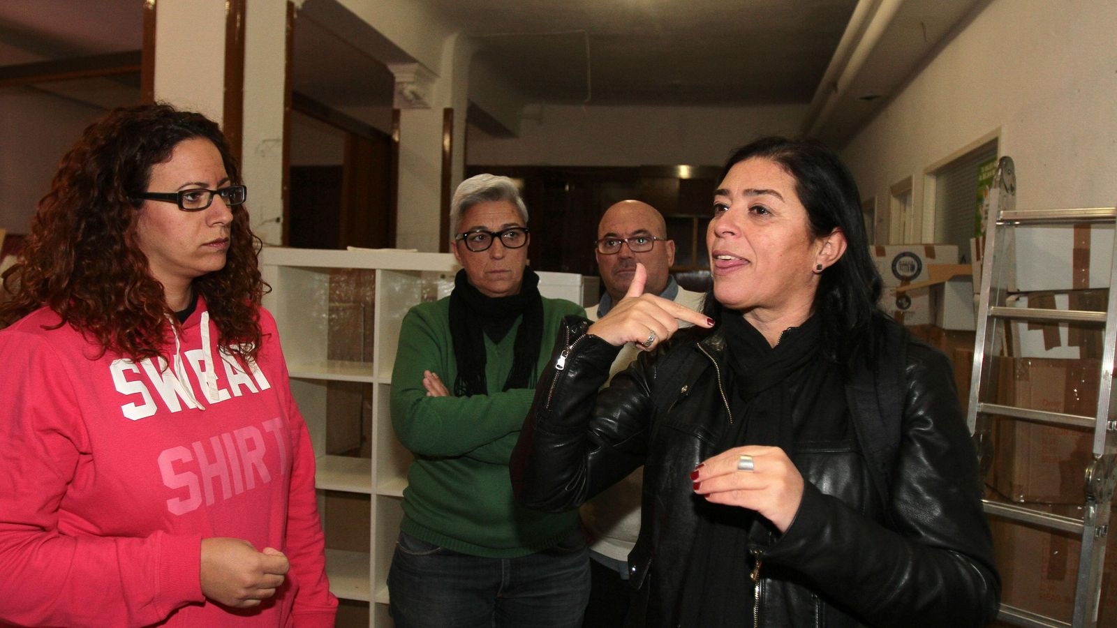 Una mujer se comunica con lengua de señas con unos compañeros