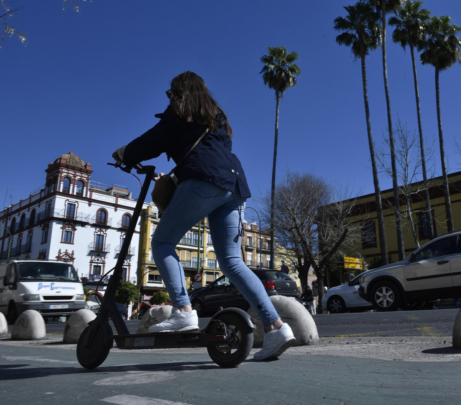 Una usuaria de un patinete eléctrico por el carril bici de la ciudad.