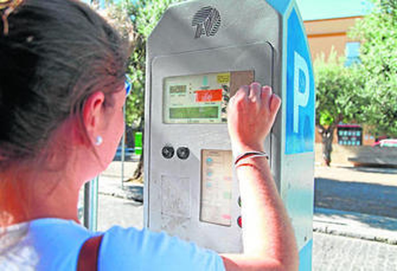Una joven introduciendo, ayer, unas monedas en una de las máquinas de la ORA.