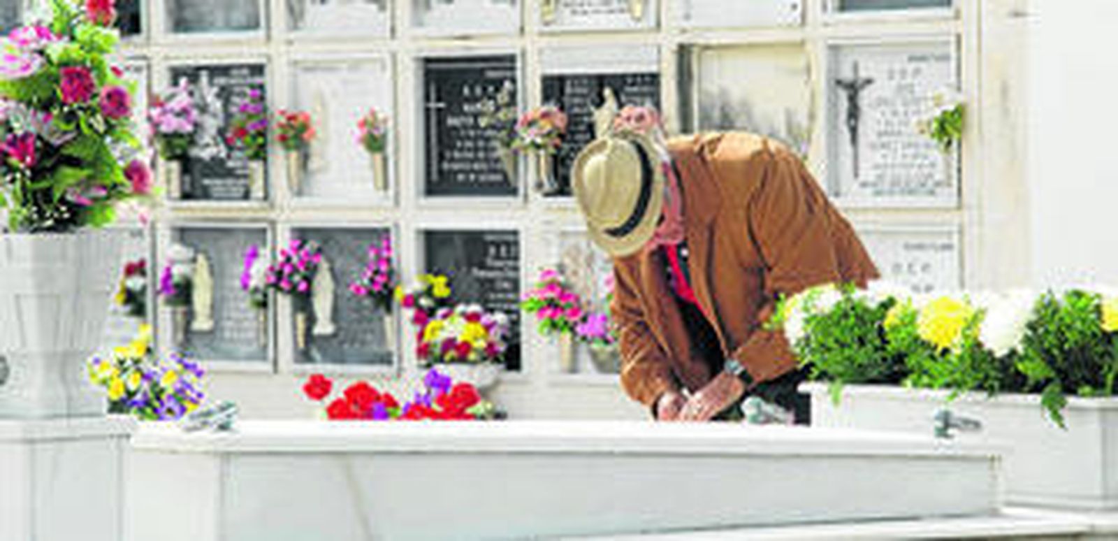 Un hombre deposita flores en una de las lápidas del Cementerio de San Roque, en Puerto Real.