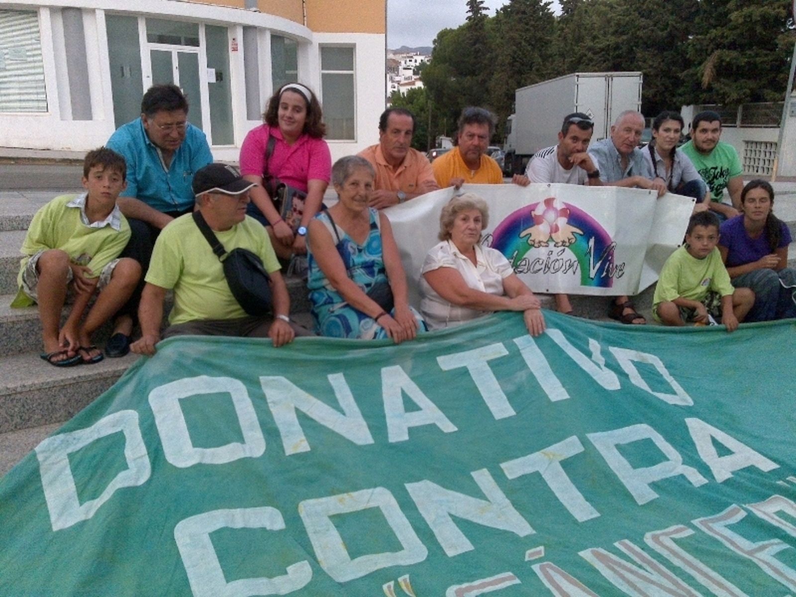 Voluntarios de la Fundación Vive posan con una pancarta.