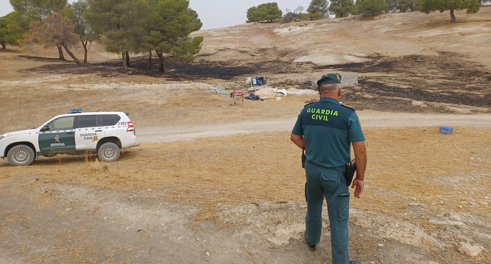 Un agente de la Guardia Civil en el terreno calcinado por el fuego.