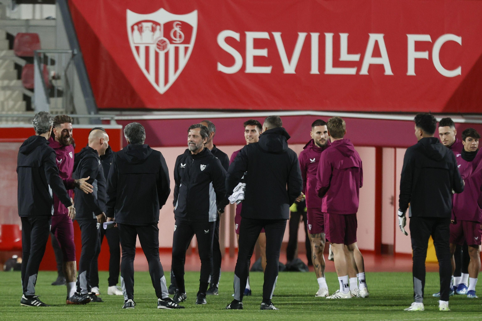 El nuevo entrenador del conjunto de Nervión, Quique Sánchez Flores, dialoga con su cuerpo técnico antes del inicio de un entrenamiento reciente.